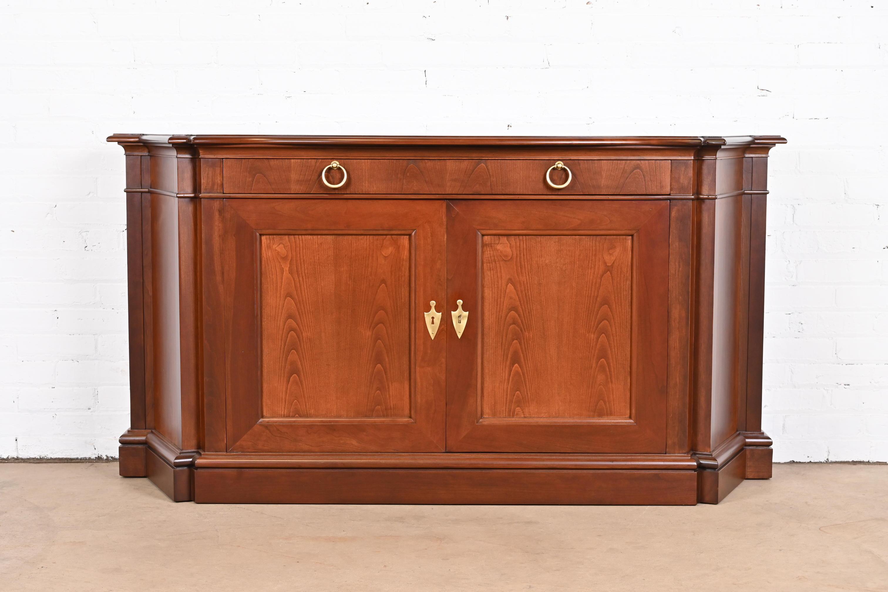An exceptional French Regency style sideboard, credenza, or bar cabinet

By Baker Furniture

USA, Circa 1960s

Gorgeous book-matched cherry wood, with original brass hardware.

Measures: 65.5