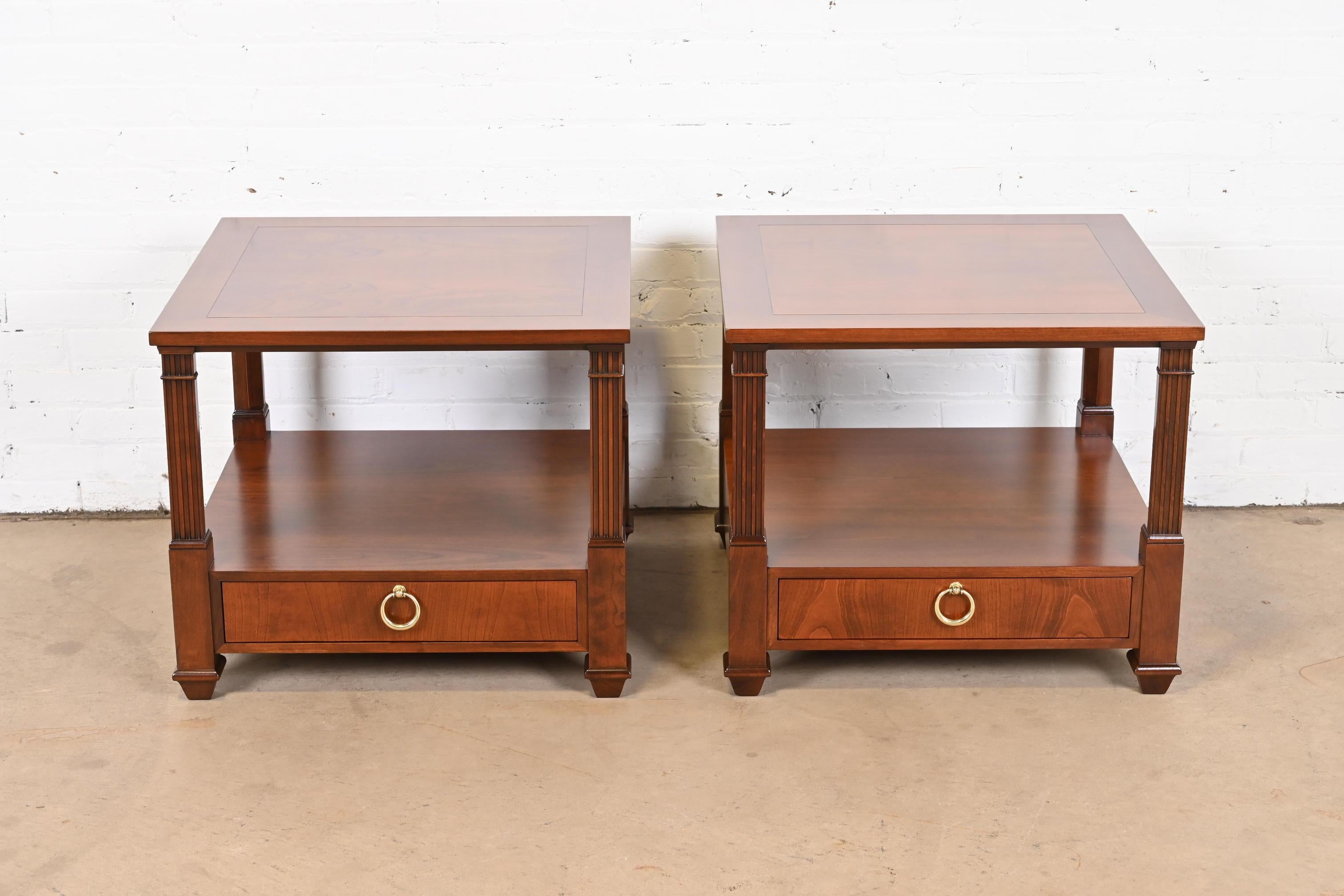 A gorgeous pair of French Regency or neoclassical style two-tier side tables or nightstands

By Baker Furniture

USA, Circa 1960s

Cherry wood, with original brass hardware

Measures: 26