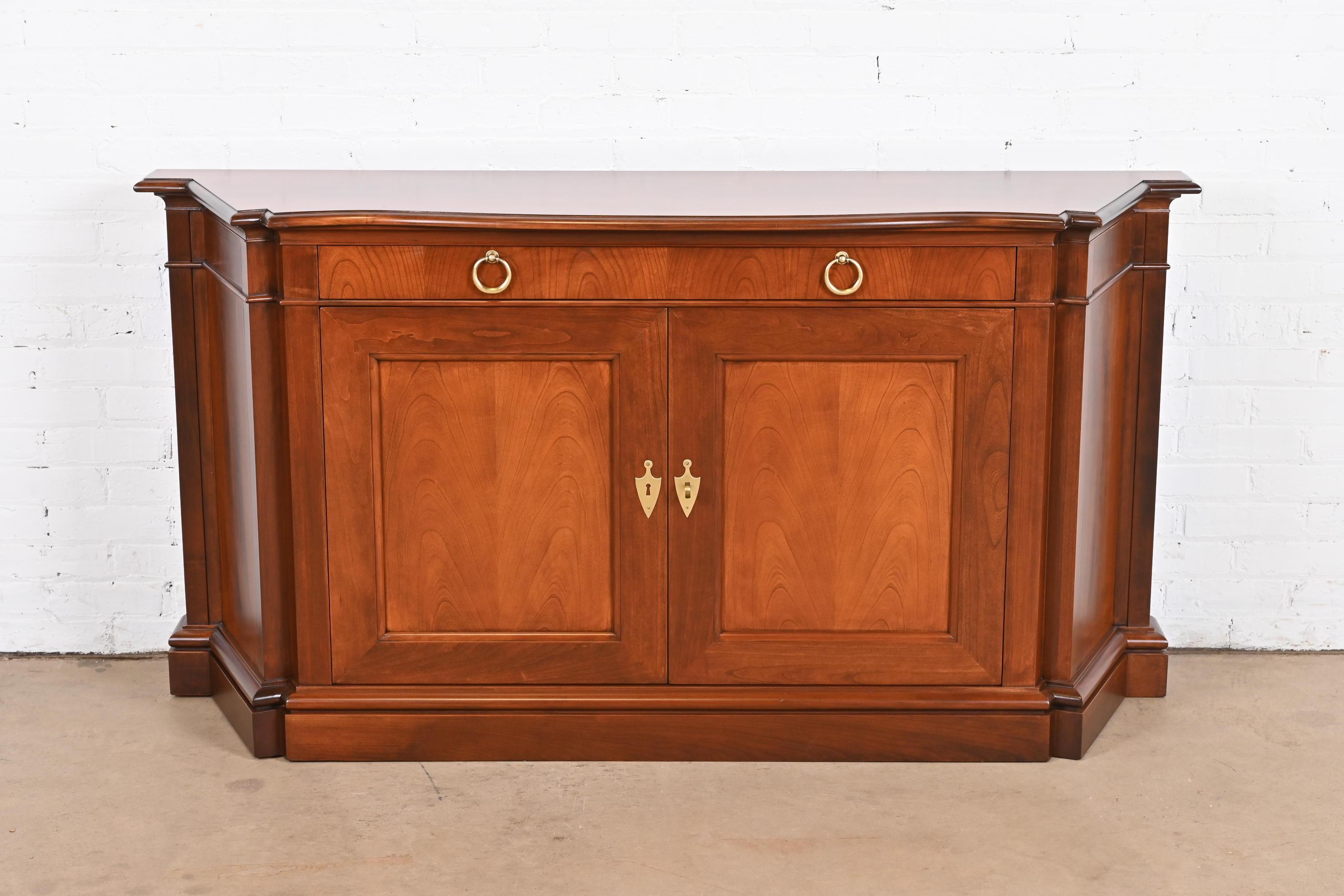A gorgeous French Regency Louis XVI style sideboard, credenza, or bar cabinet

By Baker Furniture

USA, Circa 1960s

Carved solid cherry wood, with original brass hardware. Cabinet locks, and key is included.

Measures: 65.5