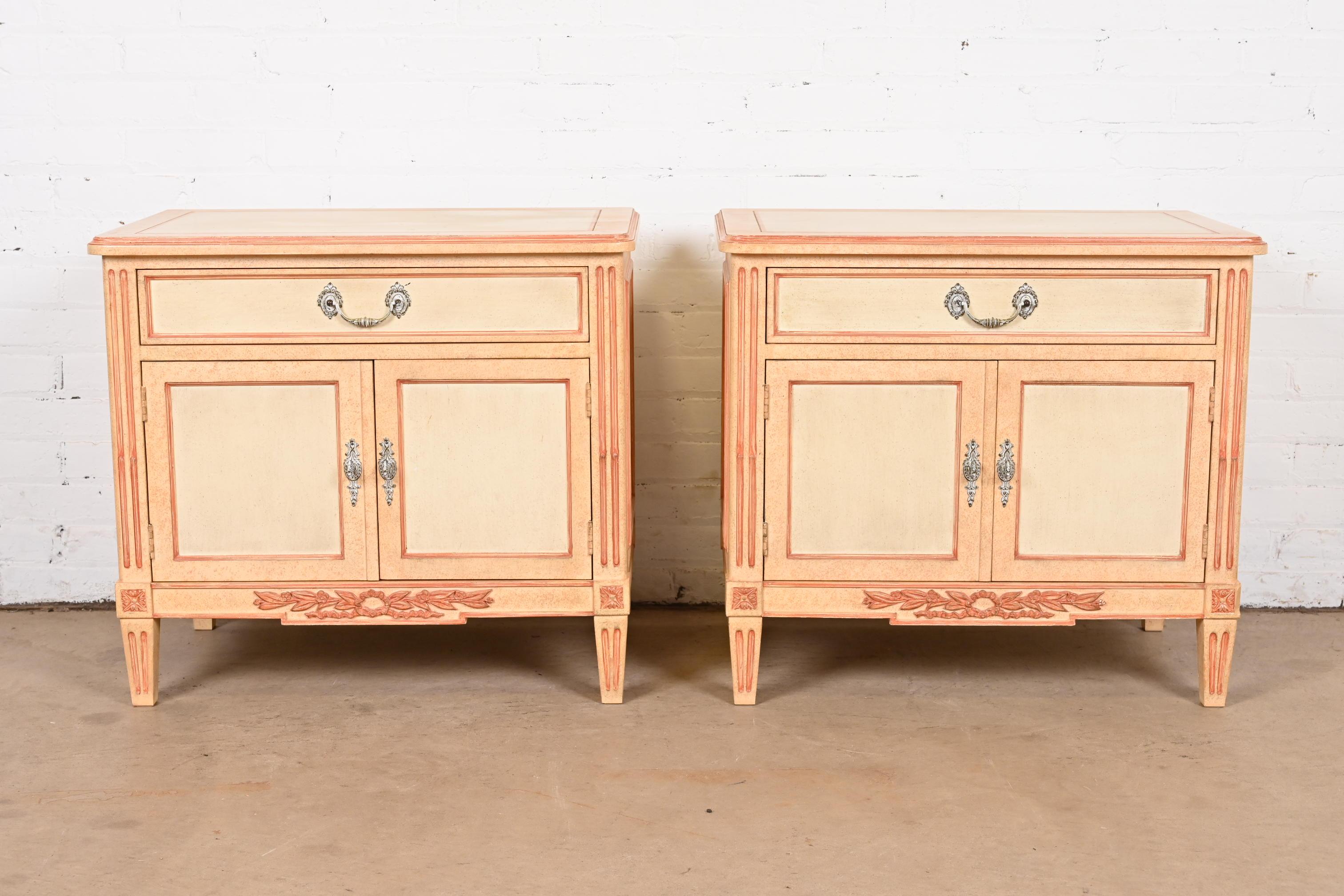 A gorgeous pair of French Regency Louis XVI or Swedish Gustavian style nightstands or bedside chests

By Baker Furniture

USA, 1960s

Carved cream painted walnut, with peachy pink trim and accents, and original brass hardware.

Measures: 28