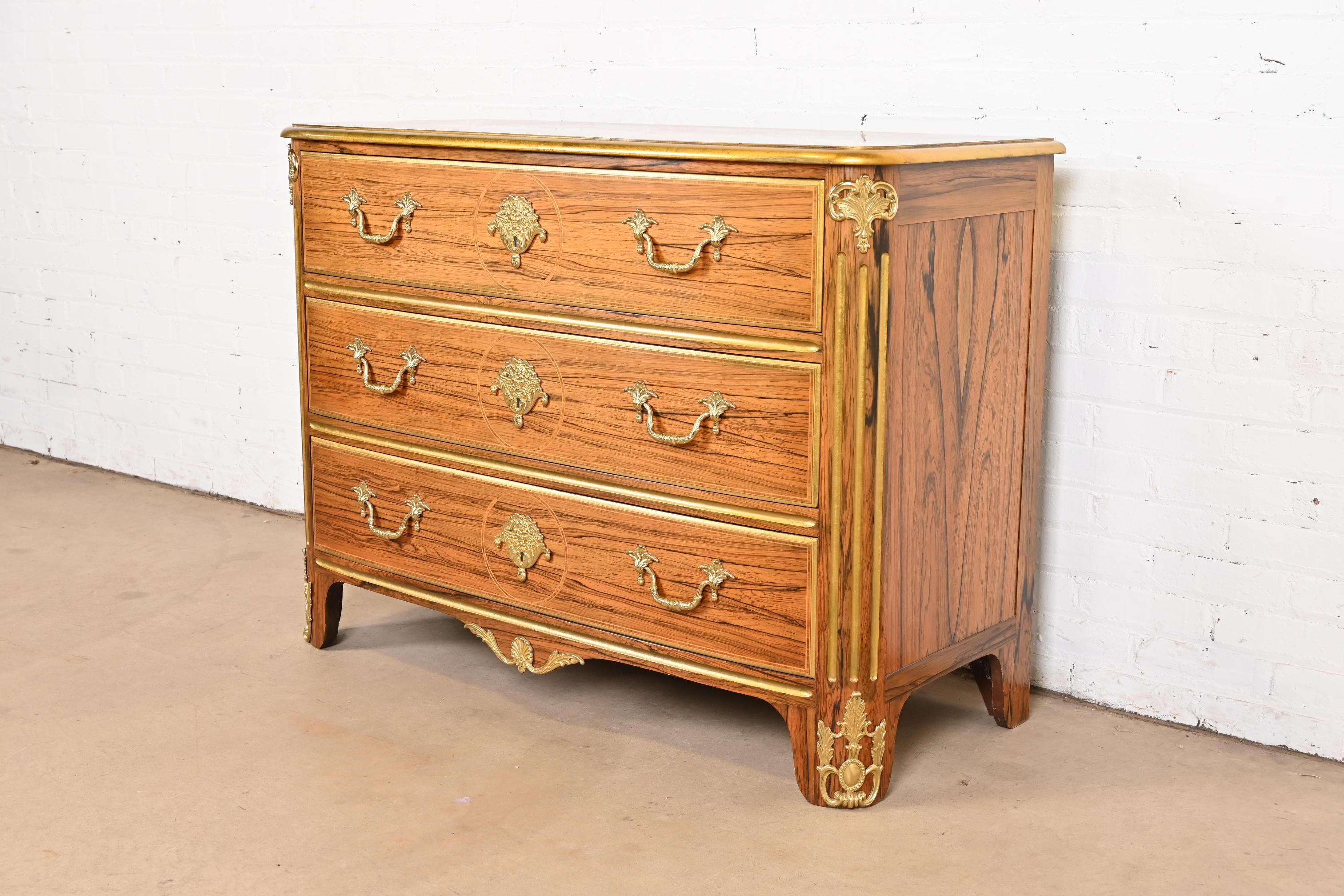 Un eccezionale comò o cassettiera in stile Regency francese Luigi XVI o Louis Philippe

Da Baker Furniture

Stati Uniti, circa fine XX secolo

Splendido legno di palissandro esotico accoppiato a libro, con finiture dorate e ormeggio in bronzo