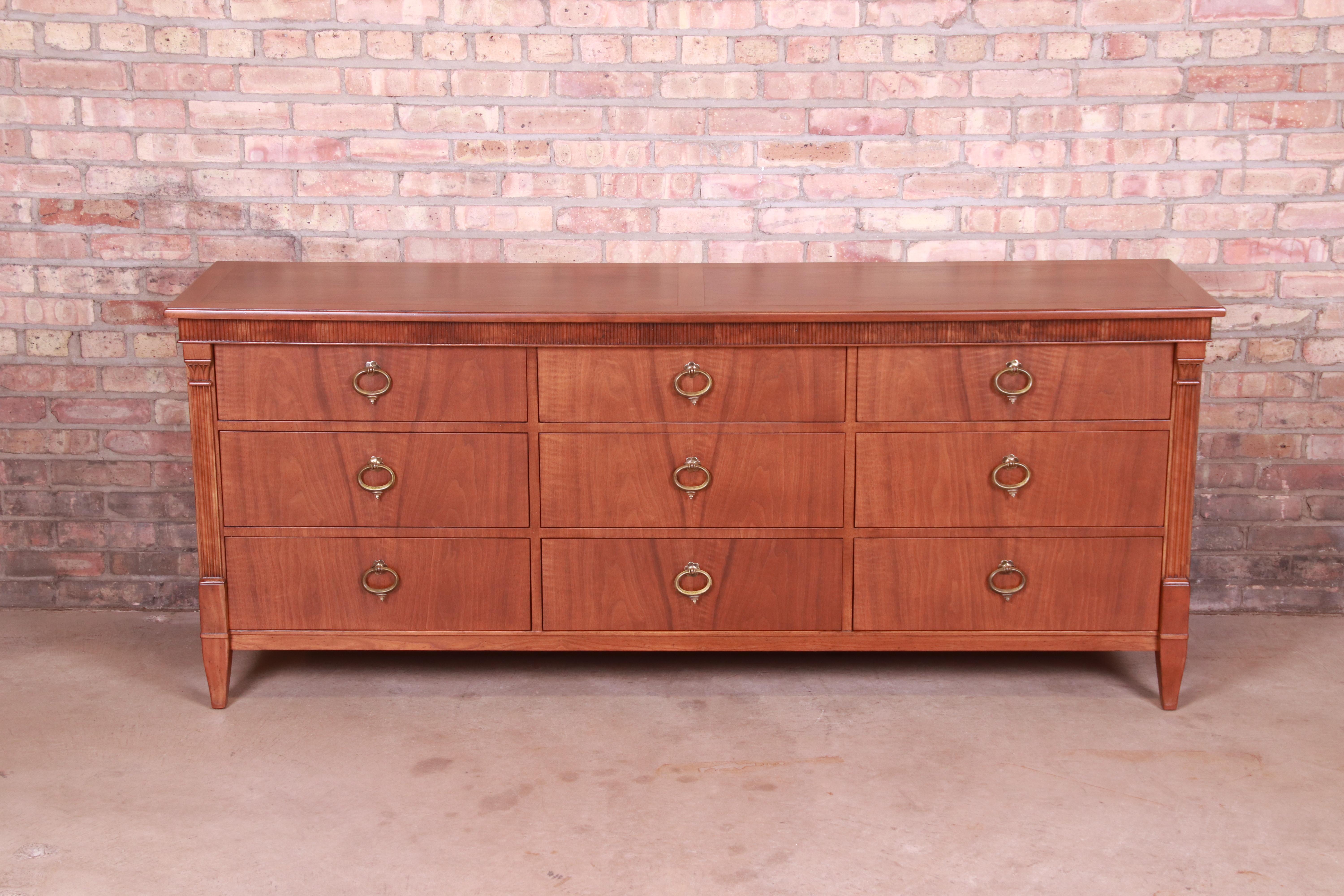 A gorgeous French Regency Louis XVI style nine-drawer dresser or credenza

By Baker Furniture

USA, Circa 1960s

Carved walnut, with original brass hardware.

Measures: 76