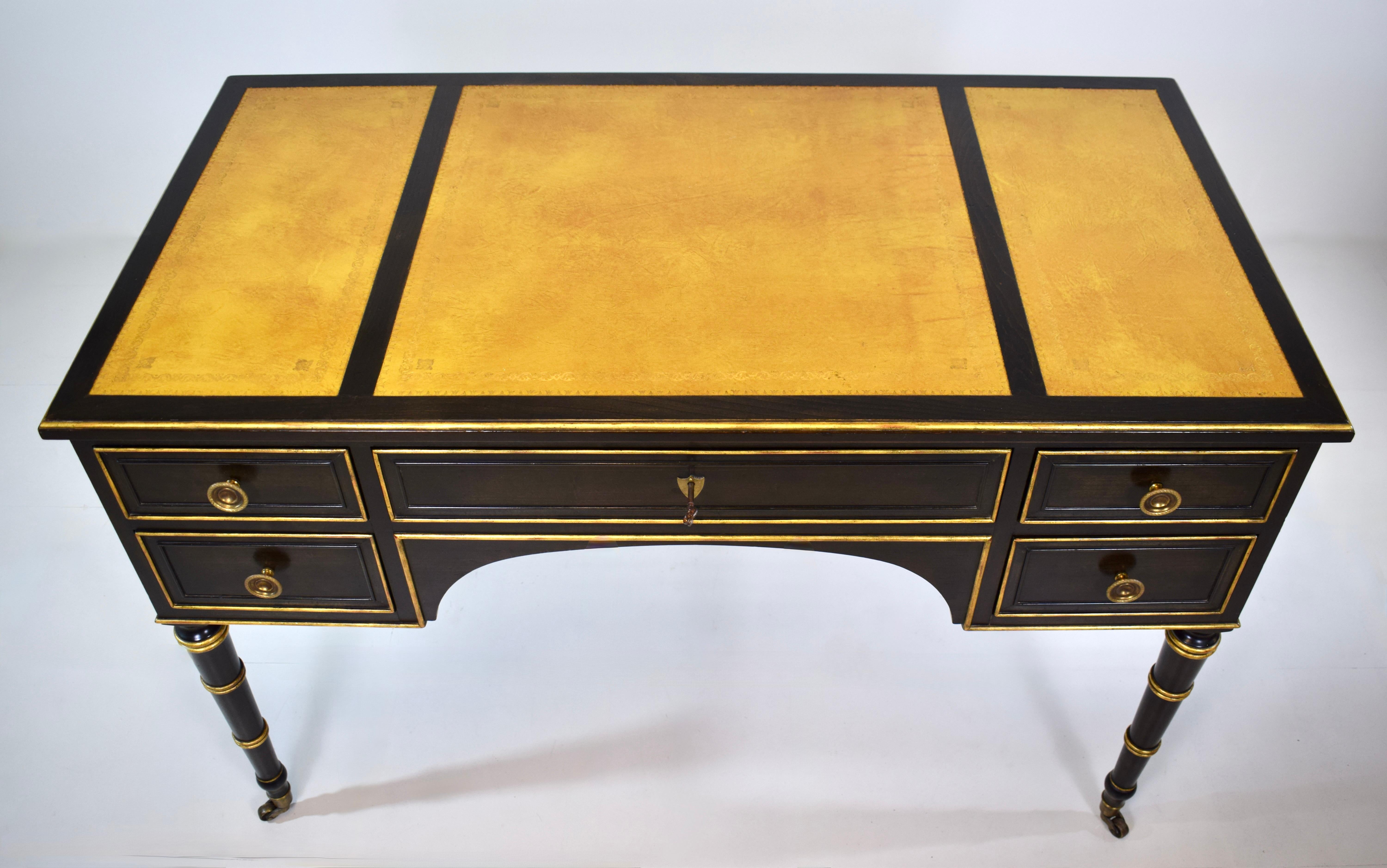 Escritorio Regency Bureau Plat de estilo Luis XVI con ruedas de latón, llamativo tablero de piel labrada, cinco cajones de cola de milano con cerradura y llave; estilo de bambú de imitación ebonizado acentuado en oro.  Baker Furniture Company hacia