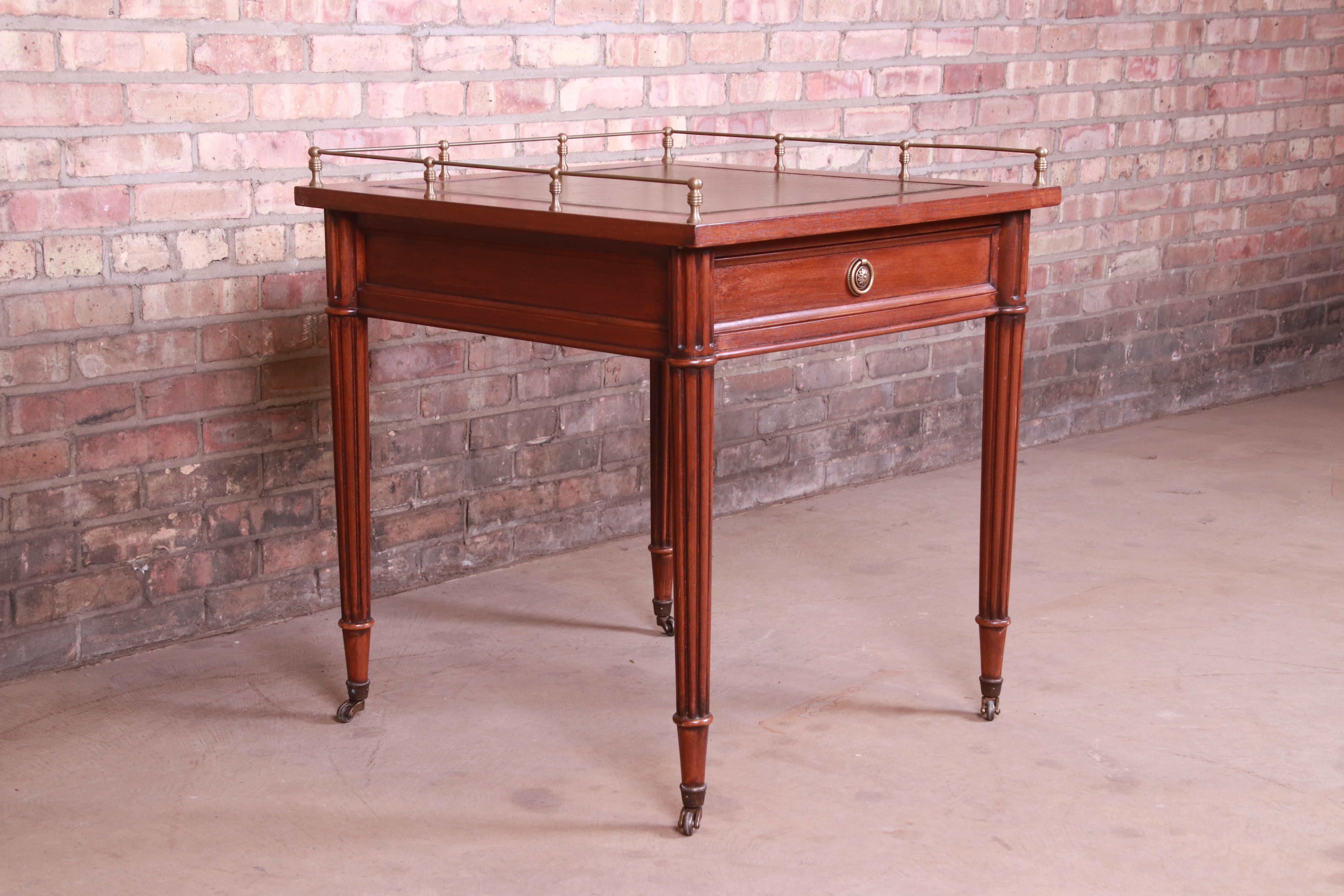 A gorgeous French Regency style single drawer tea table or side table

By Baker Furniture

USA, circa 1960s

Mahogany, with embossed green leather top and original brass gallery and hardware.

Measures: 27.5