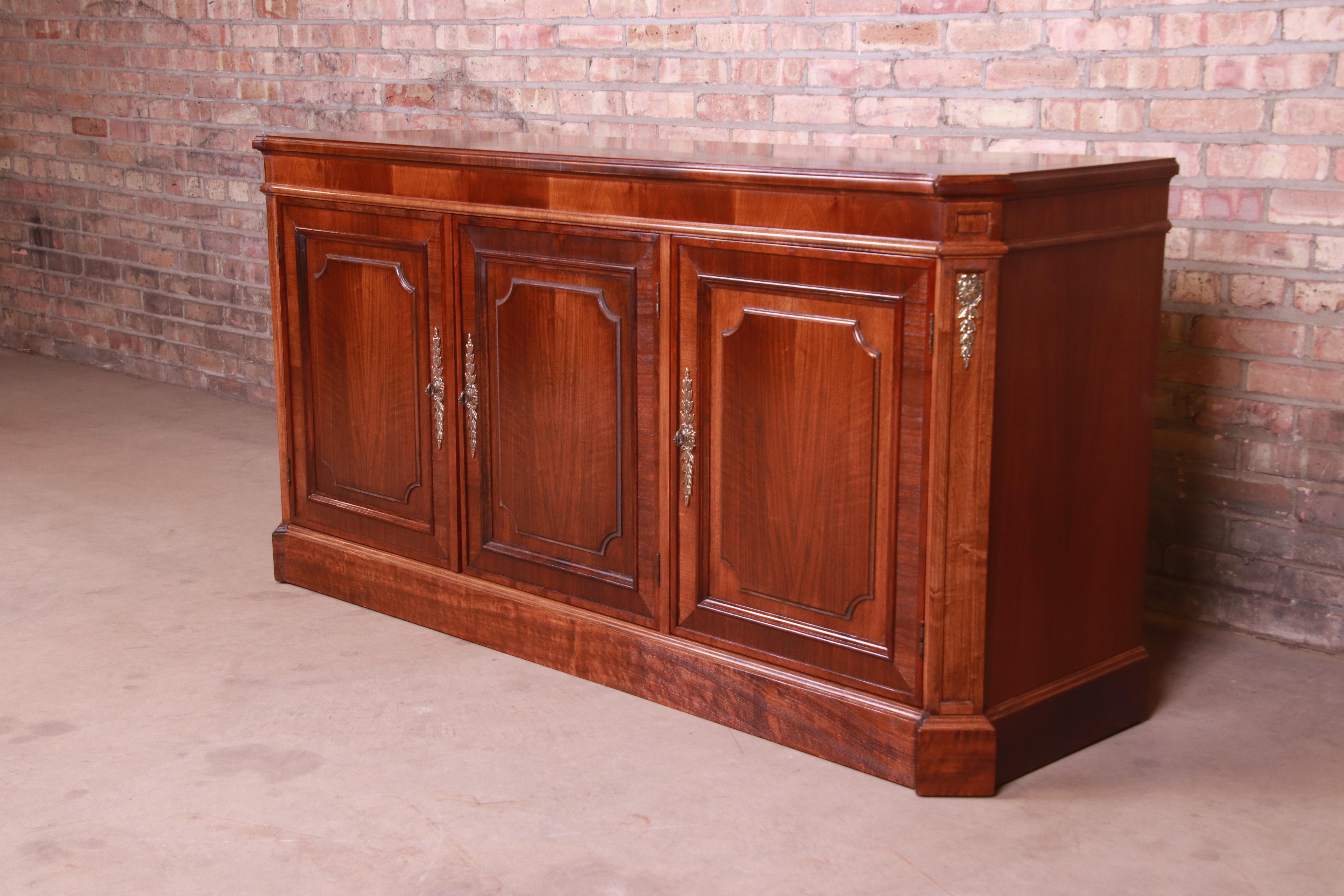 A gorgeous French Regency style sideboard, credenza, or bar cabinet

By Baker Furniture

USA, circa 1970s

Book-matched mahogany, with original brass hardware and accents.

Measures: 64