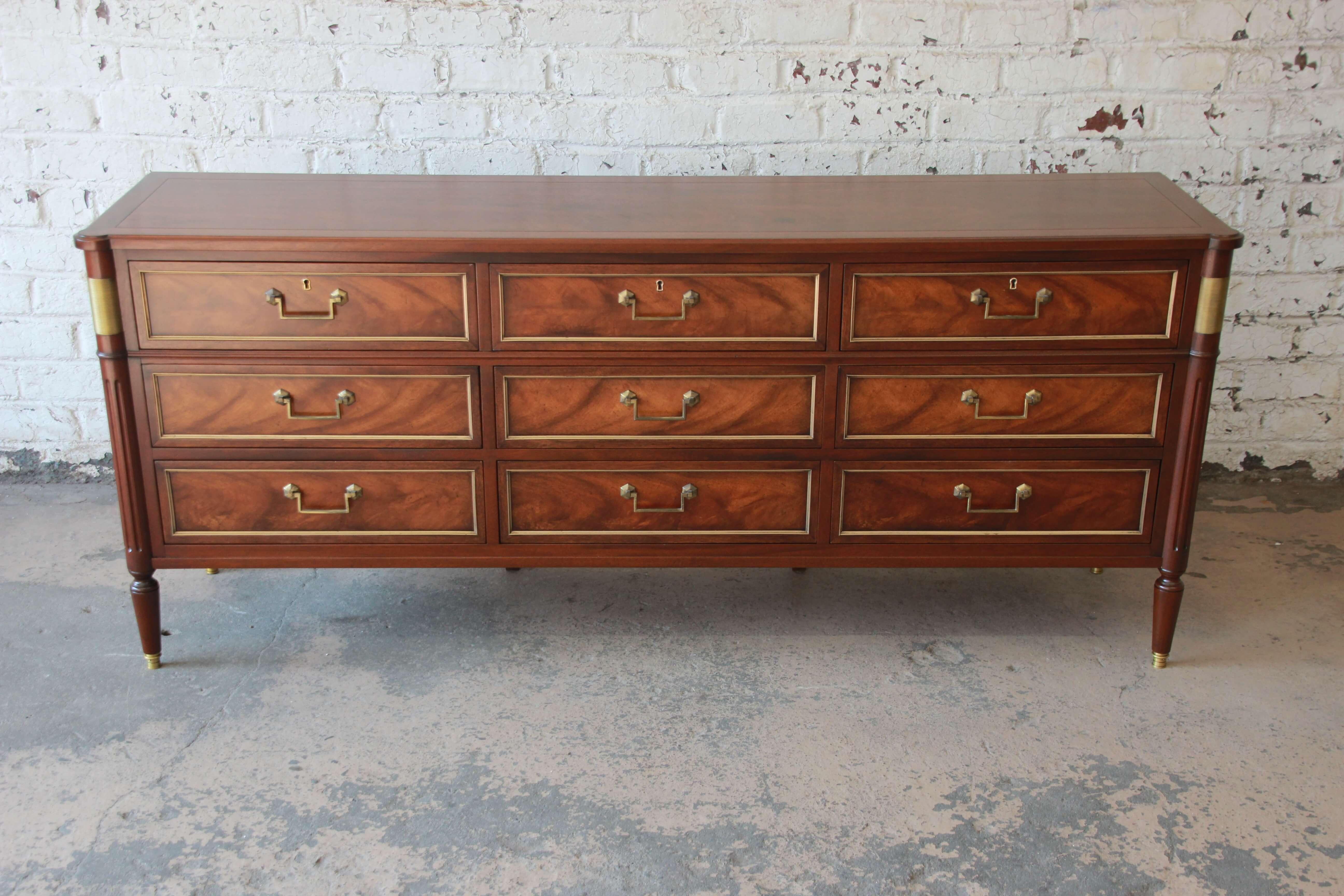 Offering a stunning Baker Furniture Regency style dresser or Credenza. The piece has been expertly refinished and features nice brass accents and stunning mahogany wood grain. Each or the nine drawers open and close smoothly with original brass