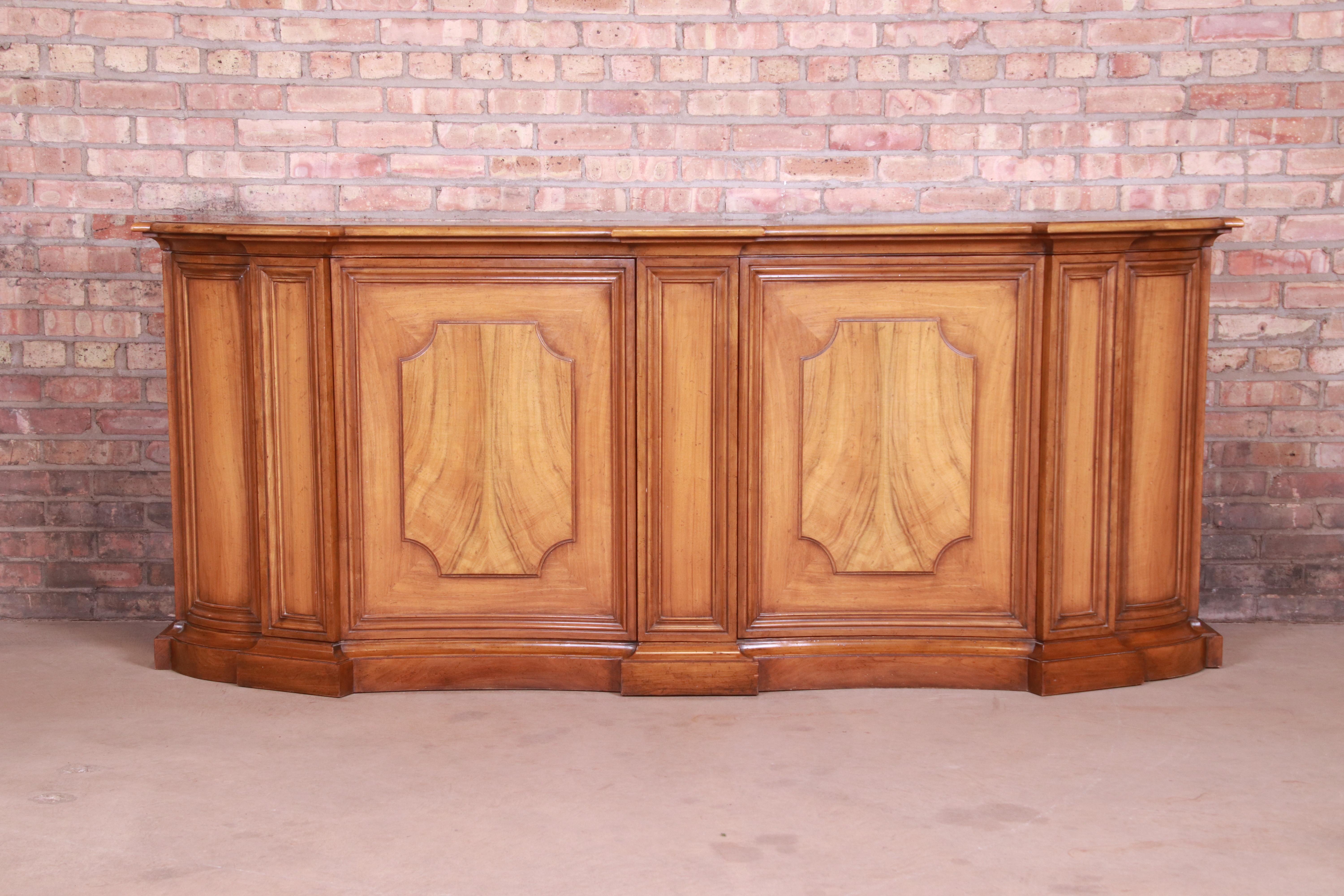 An exceptional French Regency style sideboard, credenza, or bar cabinet

By Baker Furniture

USA, circa 1960s

Inlaid walnut, with burled walnut door fronts.

Measures: 84