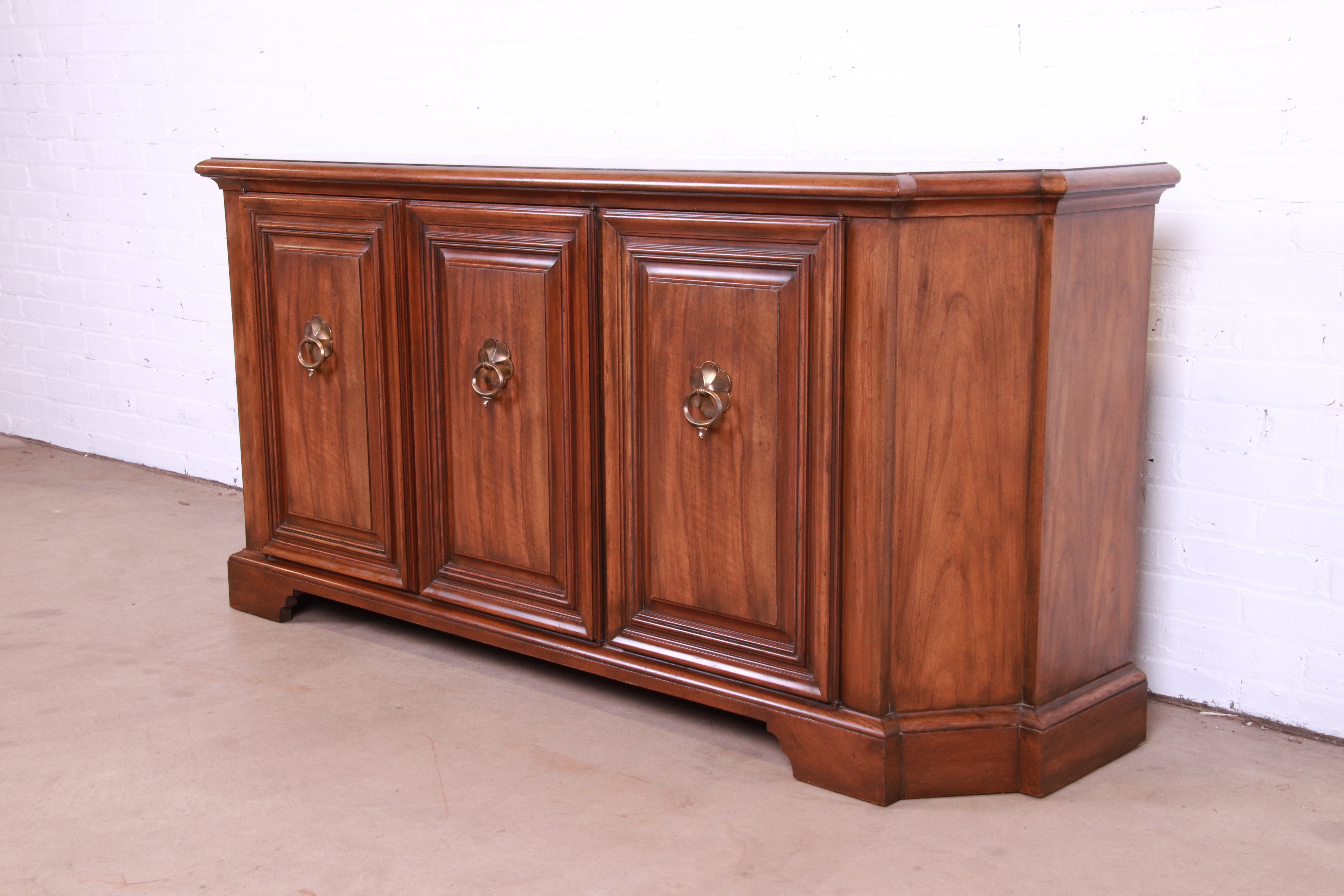 An exceptional French Regency style sideboard, credenza, or bar cabinet

By Baker Furniture

USA, Circa 1960s

Gorgeous figured walnut, with original brass hardware.

Measures: 69.25