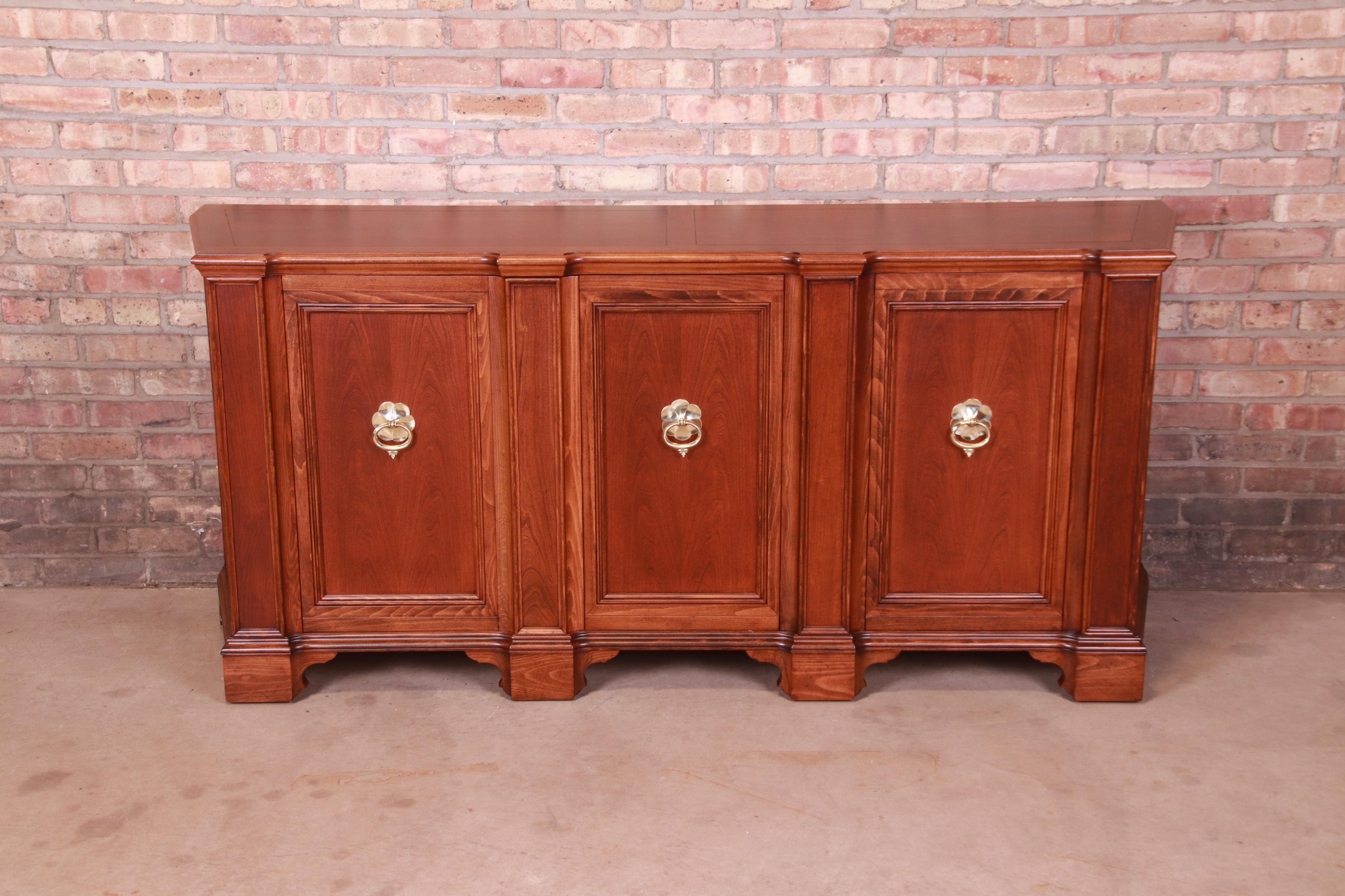 A gorgeous French Regency style sideboard, credenza, or bar cabinet

By Baker Furniture

USA, Circa 1960s

Carved walnut, with original brass hardware.

Measures: 72.5