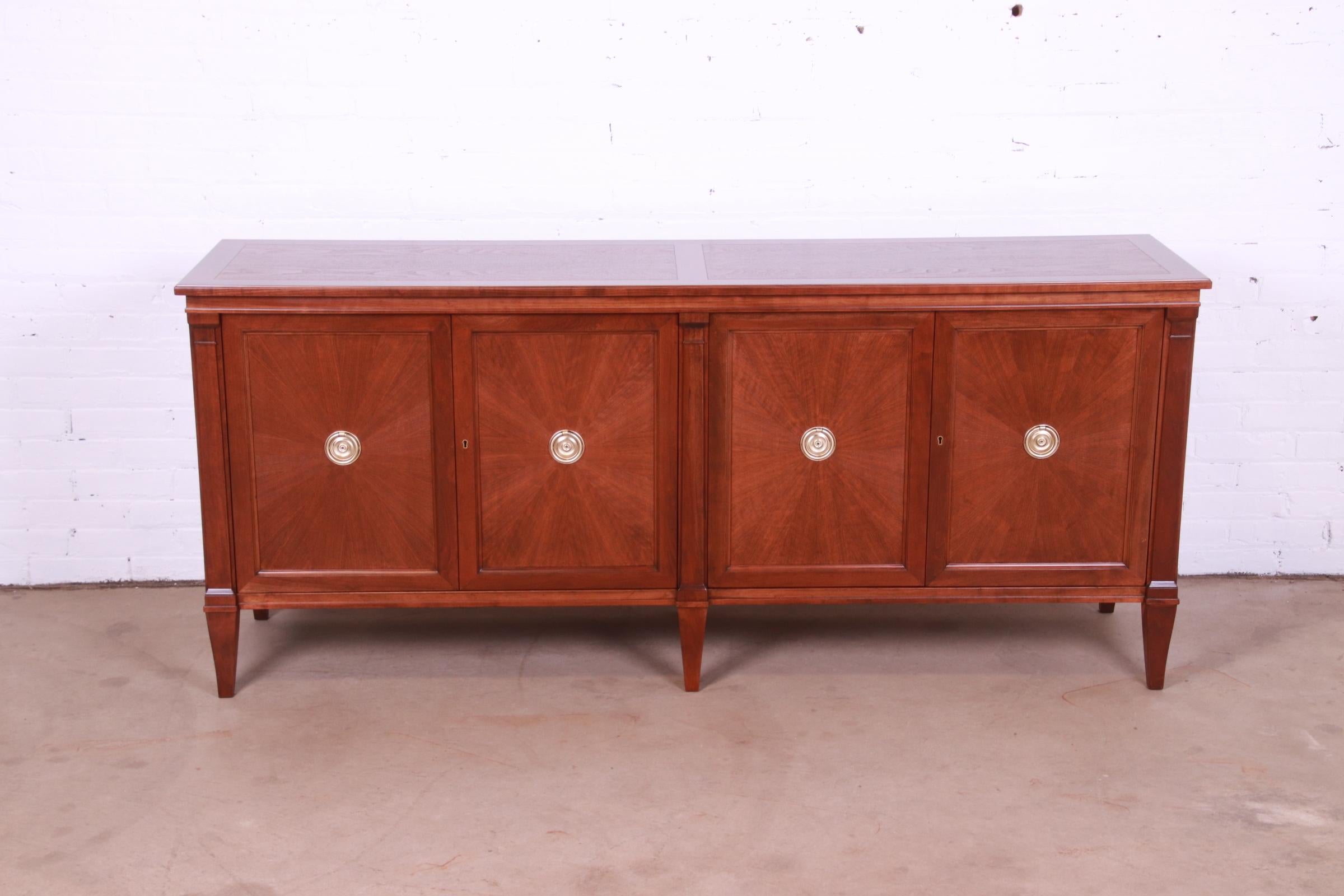 A gorgeous French Regency style sideboard, credenza, or bar cabinet

By Baker Furniture

USA, Circa 1960s

Carved walnut, with starburst design on doors, and original brass hardware.

Measures: 74.5