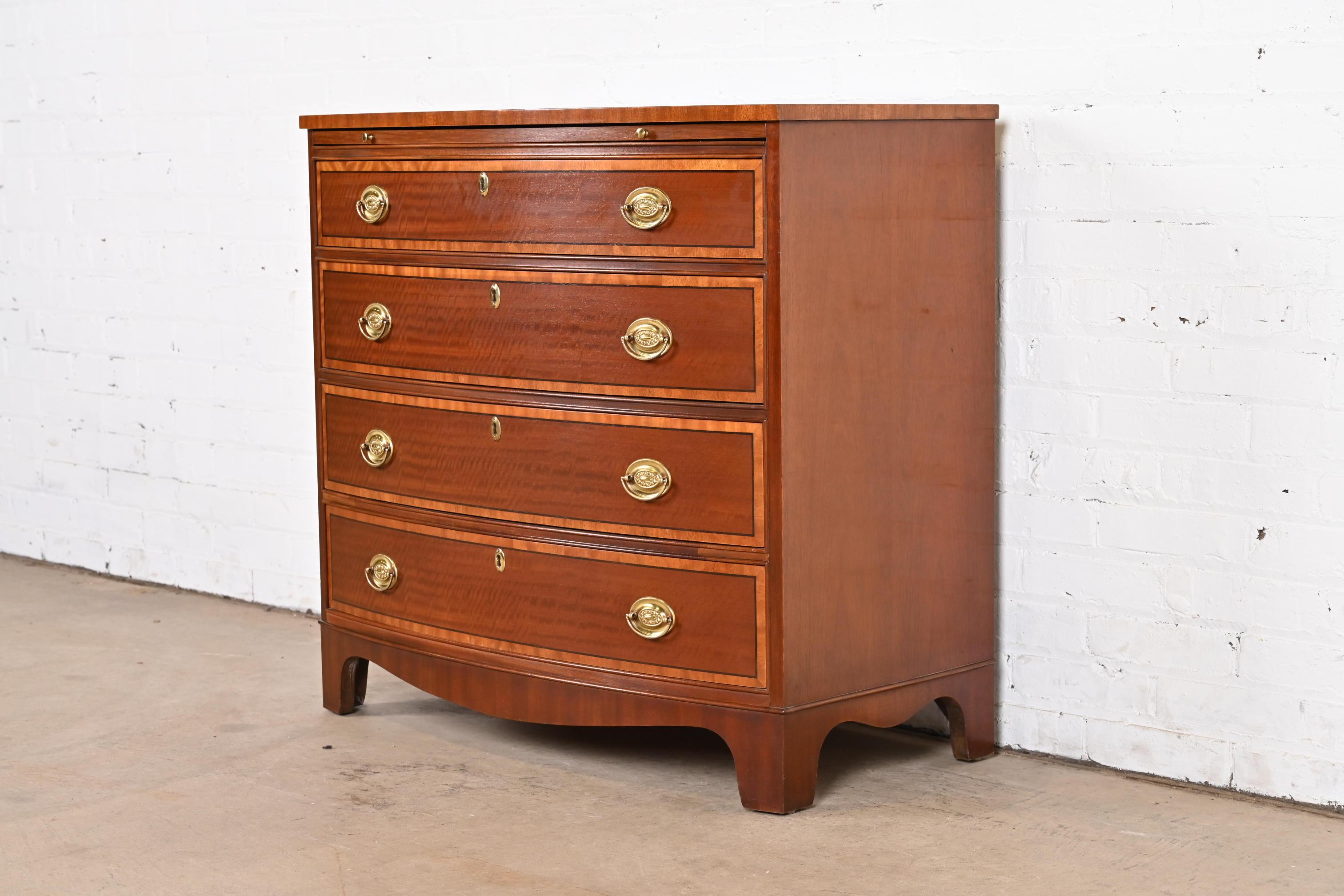 A gorgeous Georgian style bow front four-drawer commode, dresser, or bachelor chest of drawers

By Baker Furniture

USA, Circa 1980s

Mahogany, with satinwood banding and original brass hardware.

Measures: 34