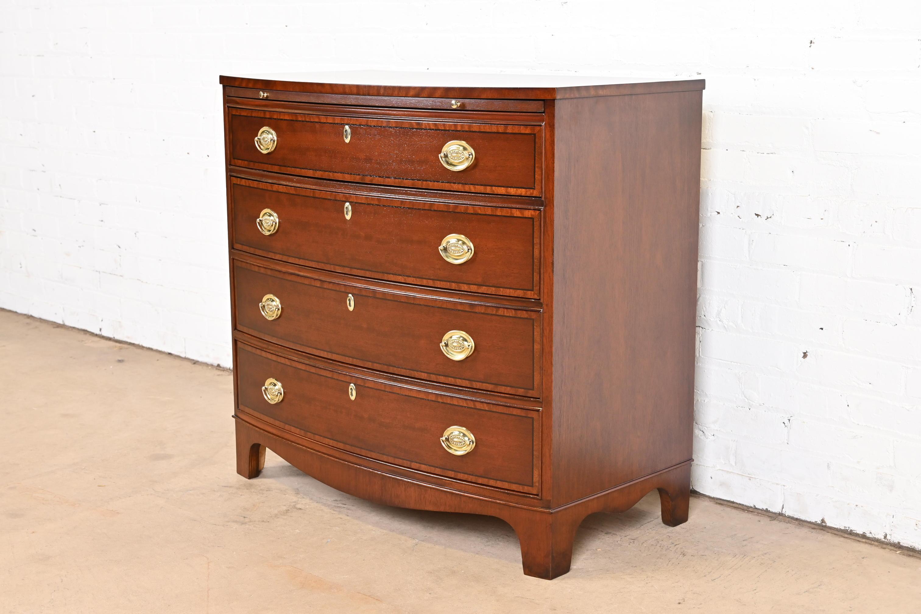 A gorgeous Georgian style bow front four-drawer commode, dresser, or chest of drawers

By Baker Furniture

USA, Circa 1980s

Mahogany, with satinwood banding and original brass hardware.

Measures: 34