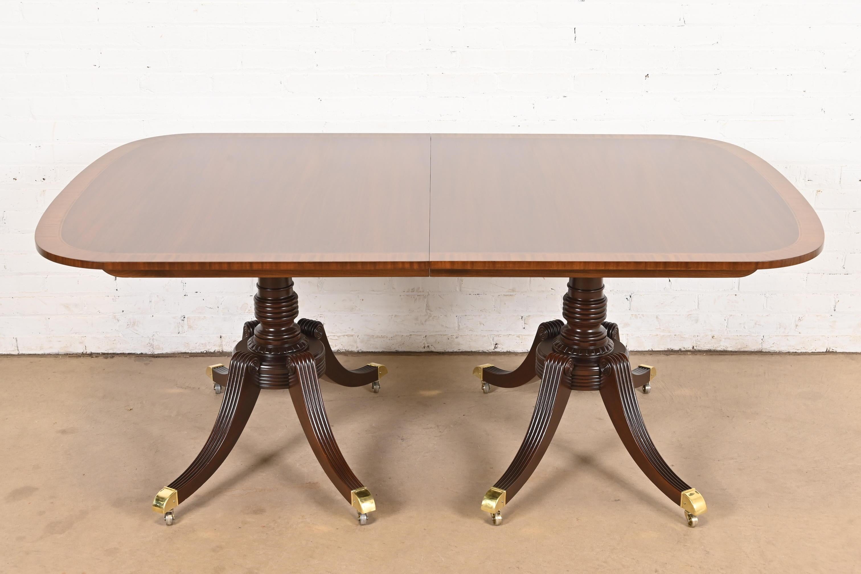 Una excepcional mesa de comedor de doble pedestal de estilo Georgiano o Regencia

Por Baker Furniture

EE.UU., alrededor de 1980

Preciosa tapa de caoba a juego con el libro, con bandas de madera satinada, pedestales de caoba maciza tallada y pies