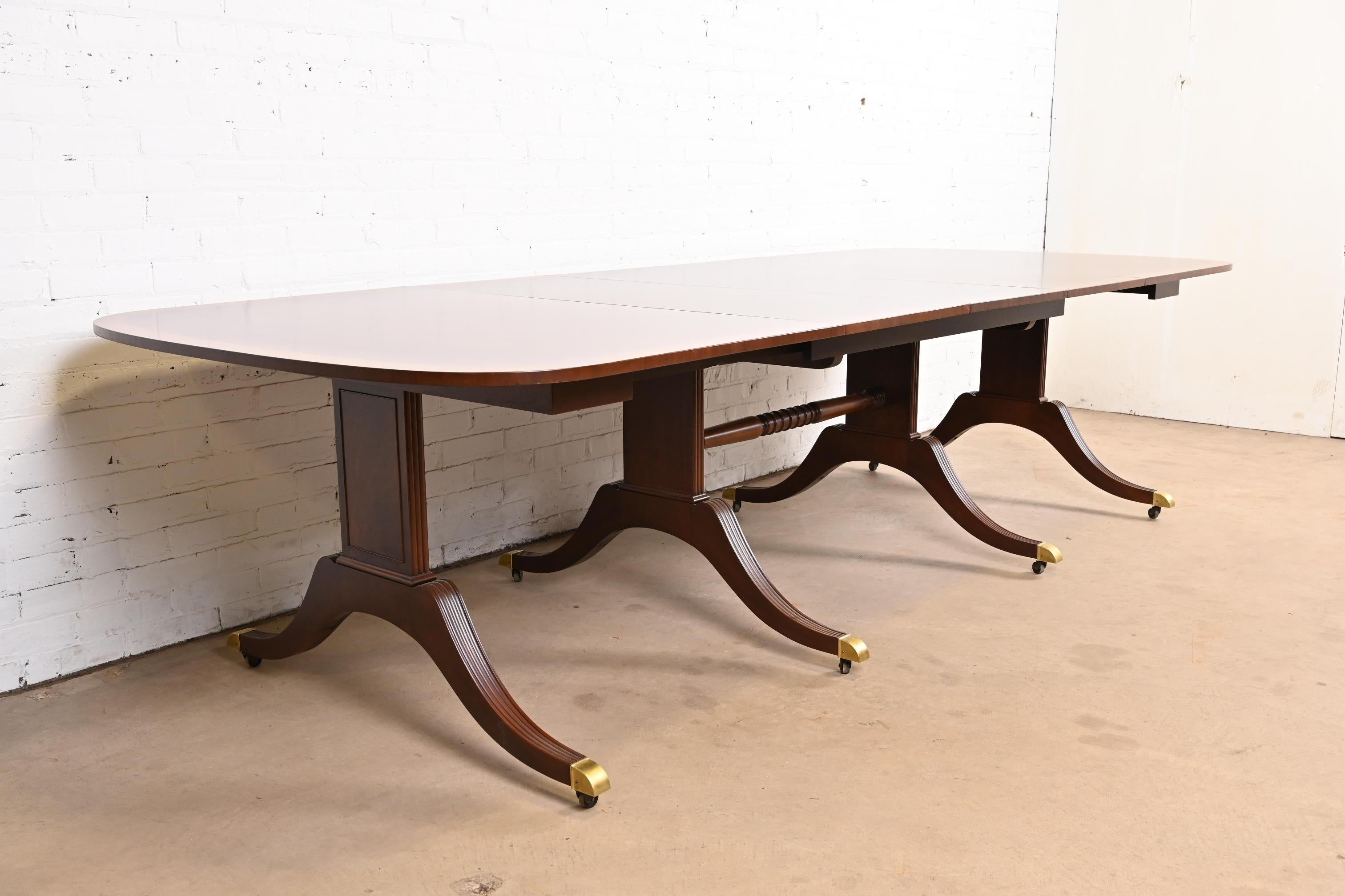 Magnifique table de salle à manger à pied de style géorgien ou régence.

Par Baker Furniture

USA, Circa 1980

Magnifique acajou, avec bandes de bois satiné, piédestaux en acajou massif sculpté, et pieds coiffés de laiton sur roulettes.

Dimensions