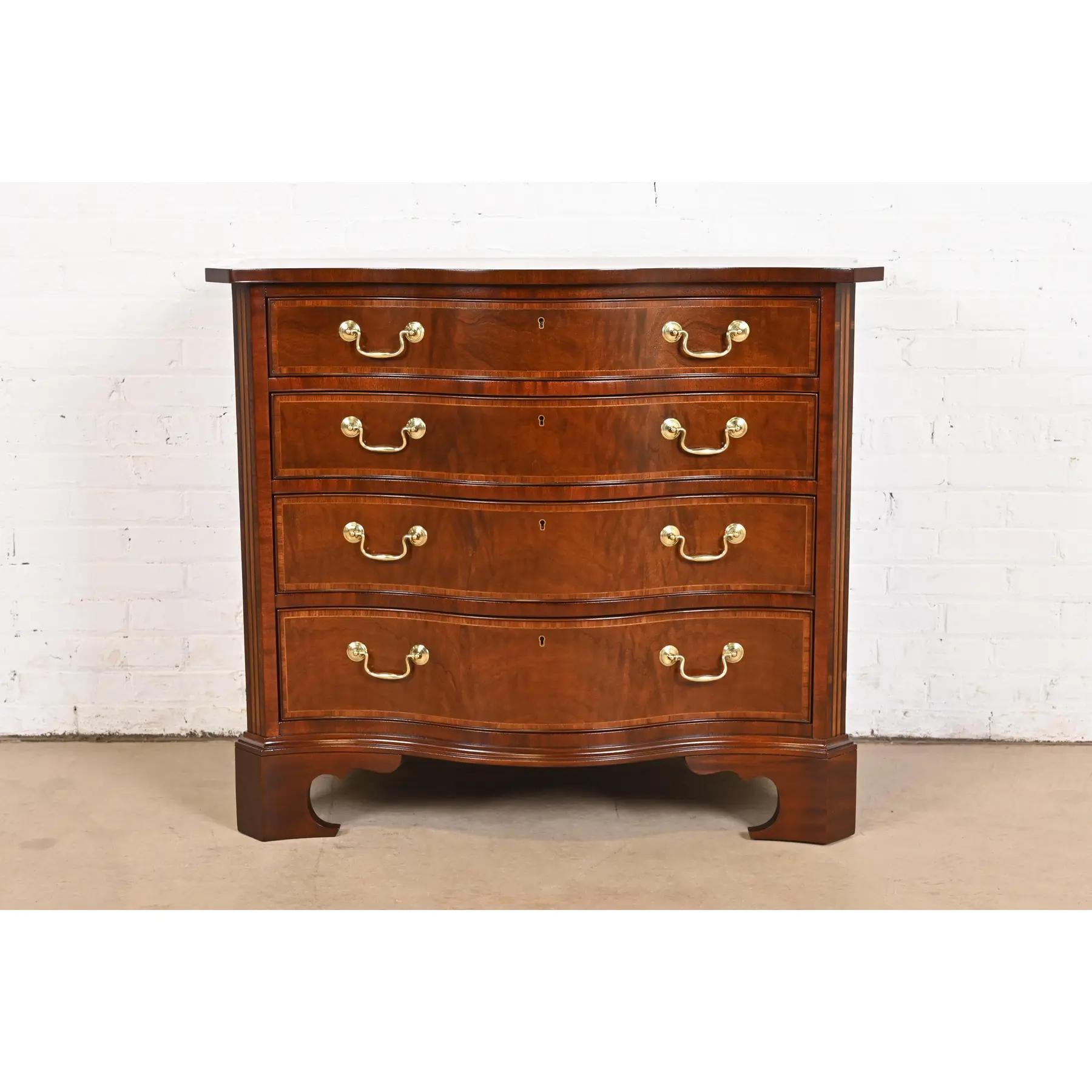 An exceptional Georgian or Chippendale style serpentine front dresser or chest of drawers

By Baker Furniture

USA, Late 20th Century

Carved mahogany, with satinwood banding and inlaid marquetry, and original brass hardware.

Measures: 41.5