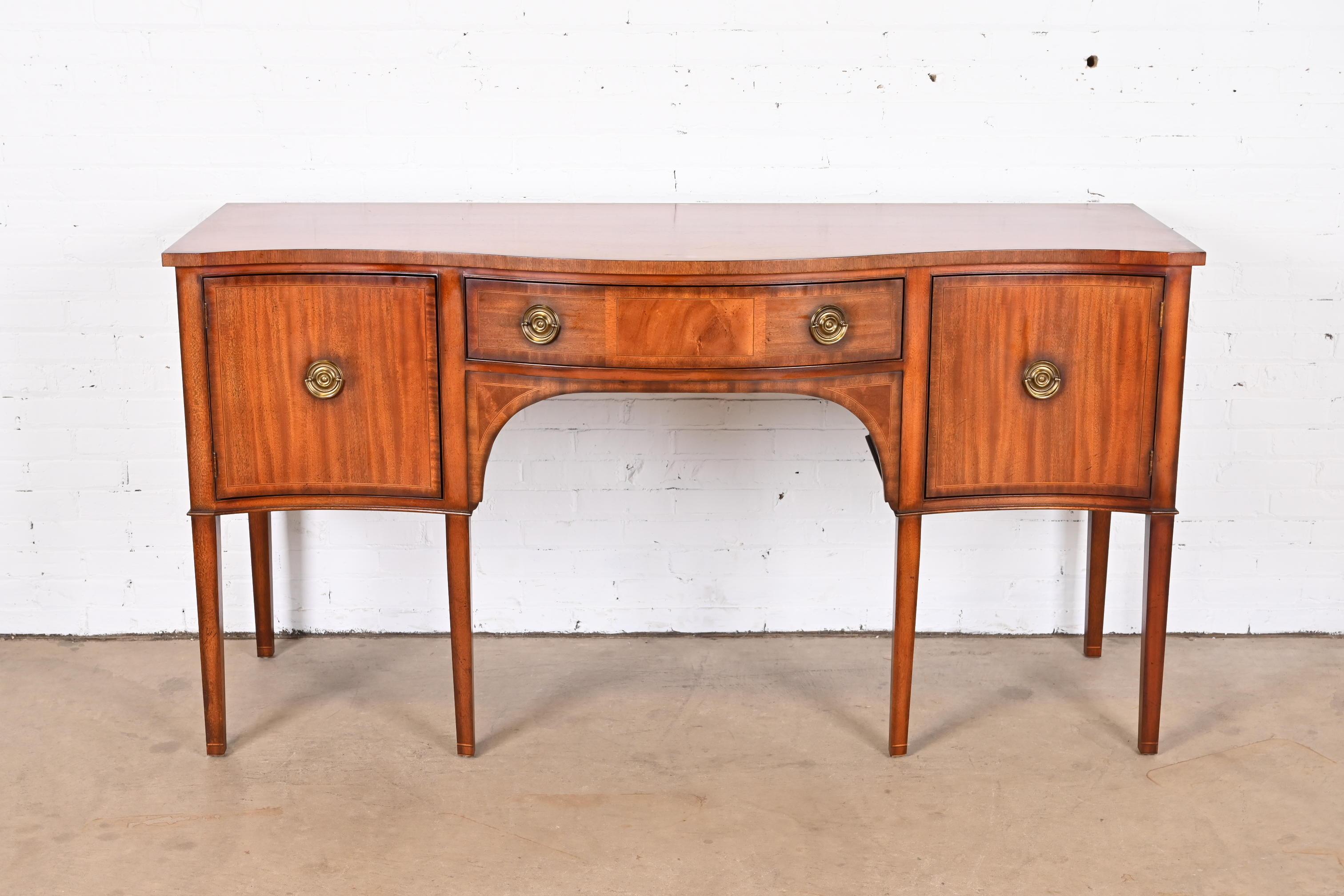 An exceptional Georgian or Hepplewhite style serpentine front sideboard, buffet, or credenza

By Baker Furniture

USA, Late 20th Century

Gorgeous mahogany, with original brass hardware and custom glass top.

Measures: 72.25
