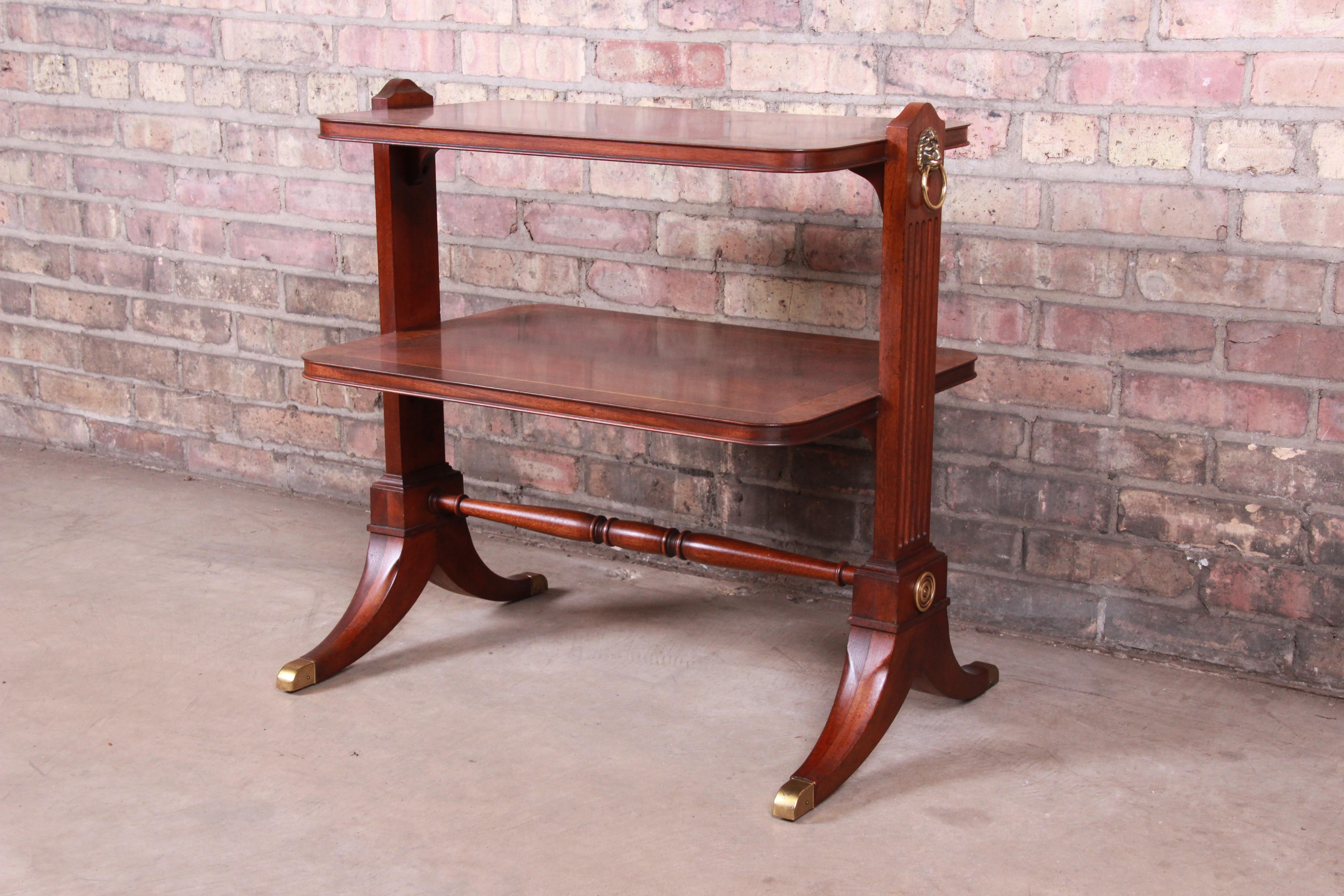 An exceptional Georgian banded mahogany two-tier occasional side table

By Baker Furniture

USA, circa 1980s

Carved mahogany, with pencil inlay and brass accents.

Measures: 27.38