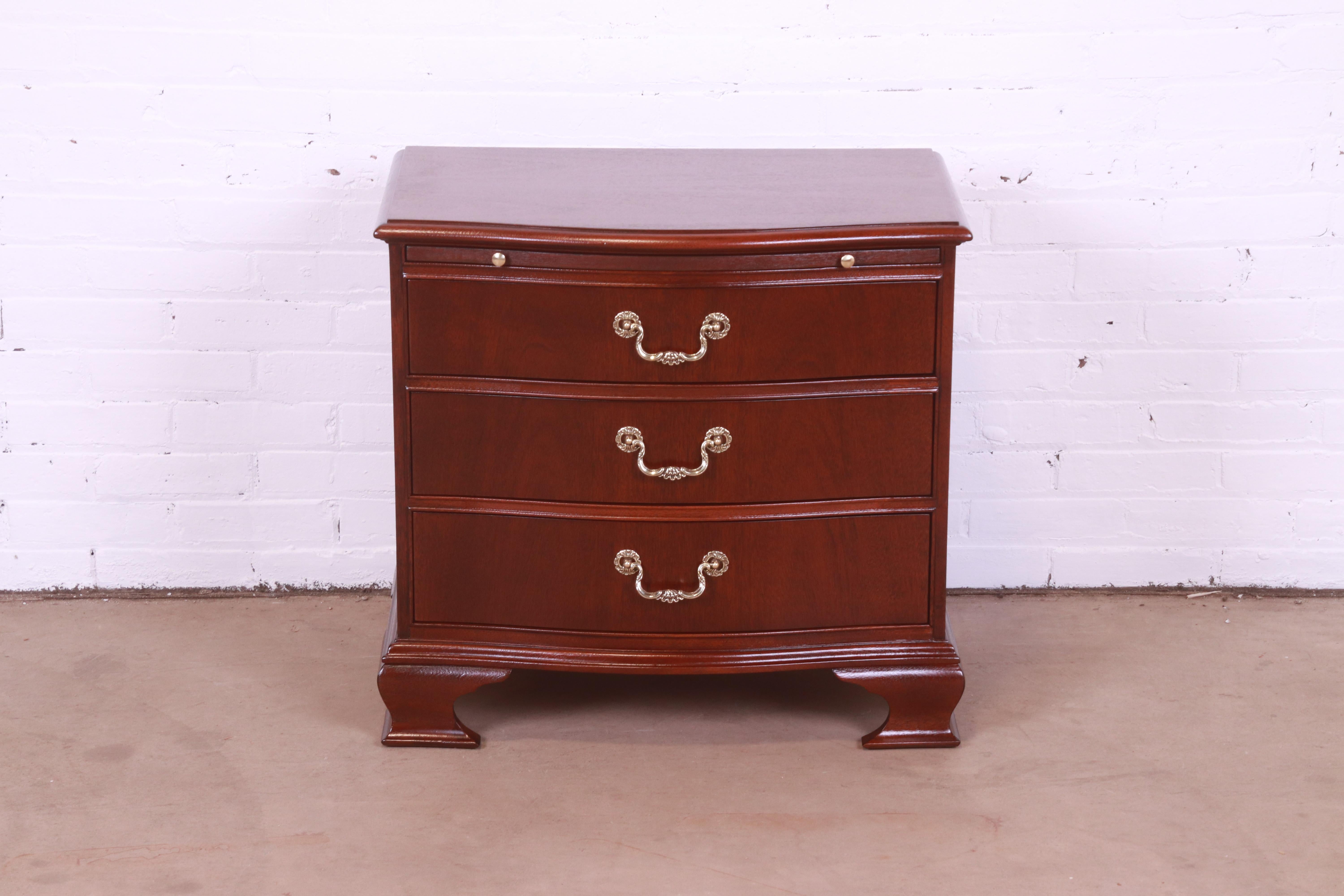 A beautiful Georgian or Chippendale style bow front three-drawer bachelor chest or nightstand

By Baker Furniture

USA, Circa 1980s

Mahogany, with original brass hardware.

Measures: 27