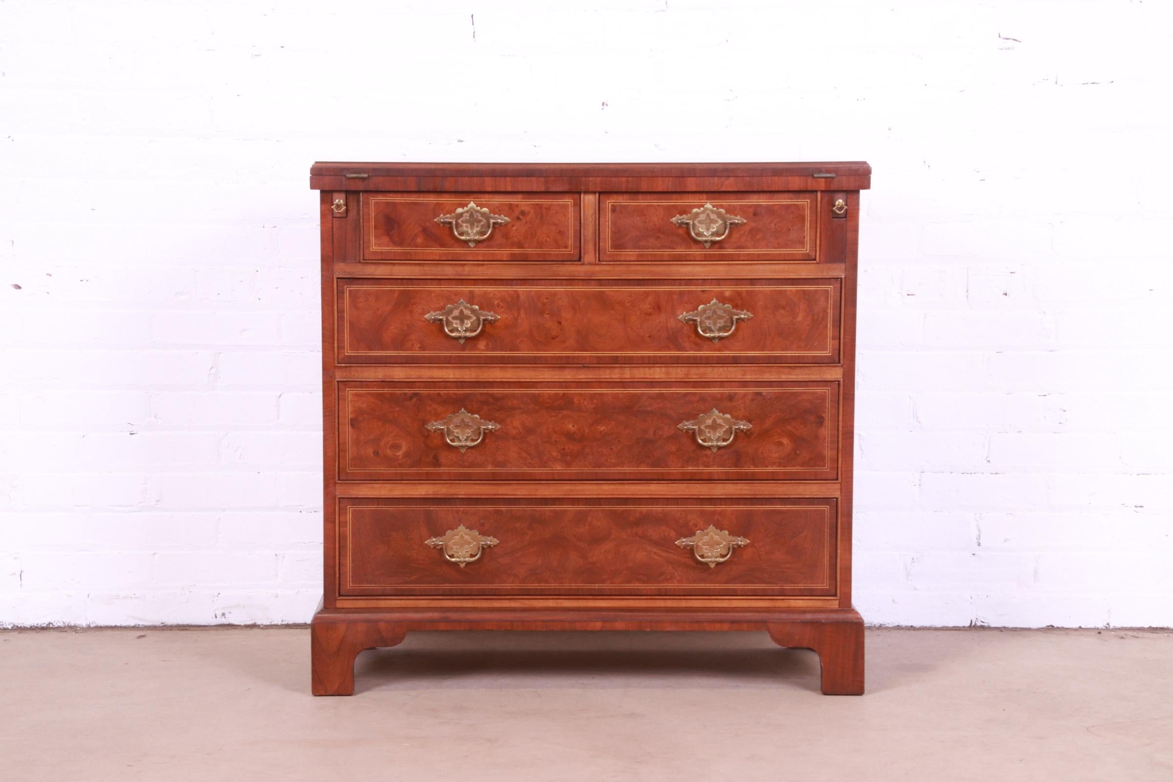 A beautiful Georgian style five-drawer flip top dresser or chest of drawers

By Baker Furniture

USA, Circa 1980s

Burled walnut, with inlaid satinwood and original brass hardware.

Measures: 32.38