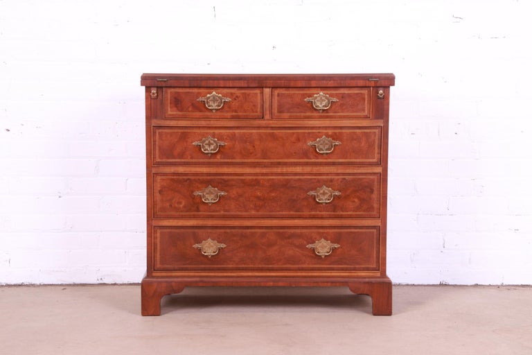A beautiful Georgian style five-drawer flip top dresser or chest of drawers

By Baker Furniture

USA, Circa 1980s

Burled walnut, with inlaid satinwood and original brass hardware.

Measures: 32.38