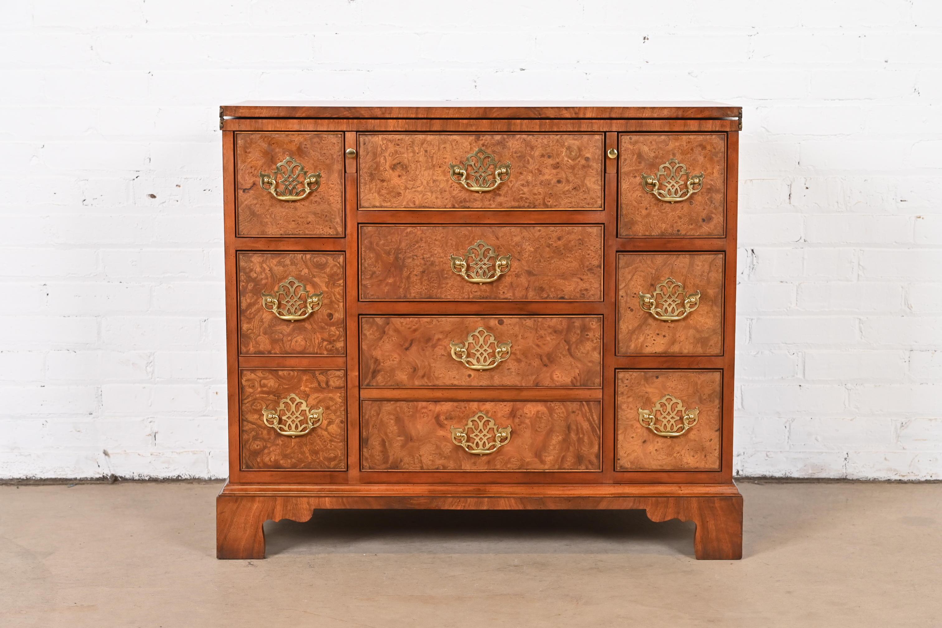 An exceptional Georgian or Chippendale style flip top dresser or bachelor chest of drawers

By Baker Furniture

USA, Circa 1980s

Walnut, with gorgeous figural burled walnut drawer fronts, and original brass hardware.

Measures: 35