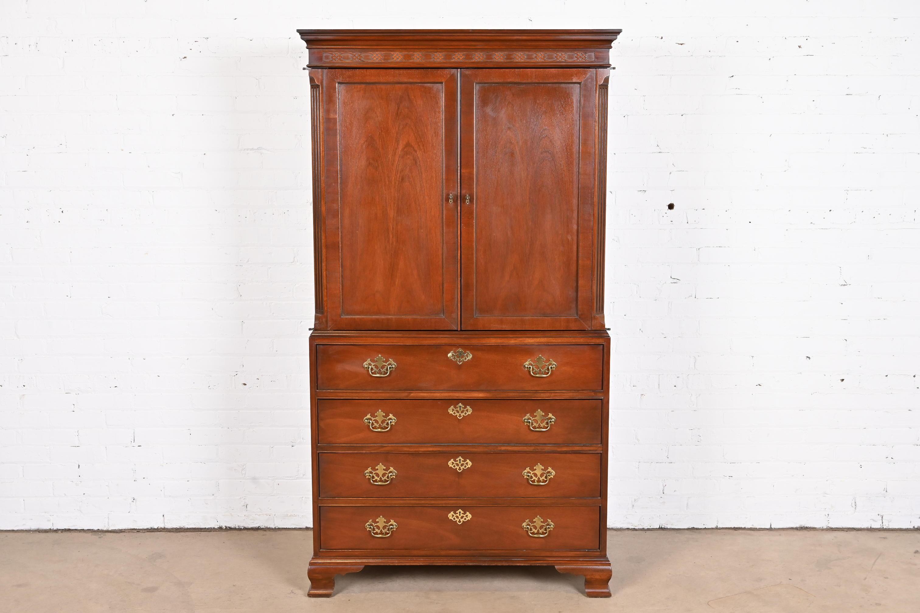 A gorgeous Georgian or Chippendale style armoire dresser, linen press, or media cabinet

By Baker Furniture

USA, circa 1980s

Carved mahogany, with original brass hardware.

Measures: 39.25