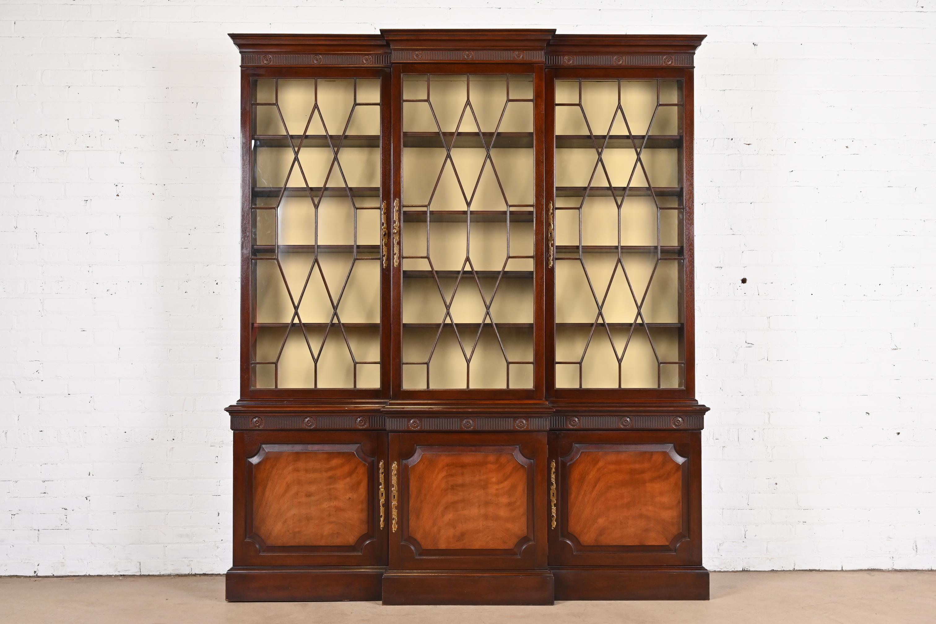 A gorgeous Georgian or Chippendale style breakfront bookcase or dining cabinet

By Baker Furniture

USA, Circa 1960s

Carved mahogany, with mullioned glass front doors, and original brass hardware. Cabinet locks, and key is included.

Measures: