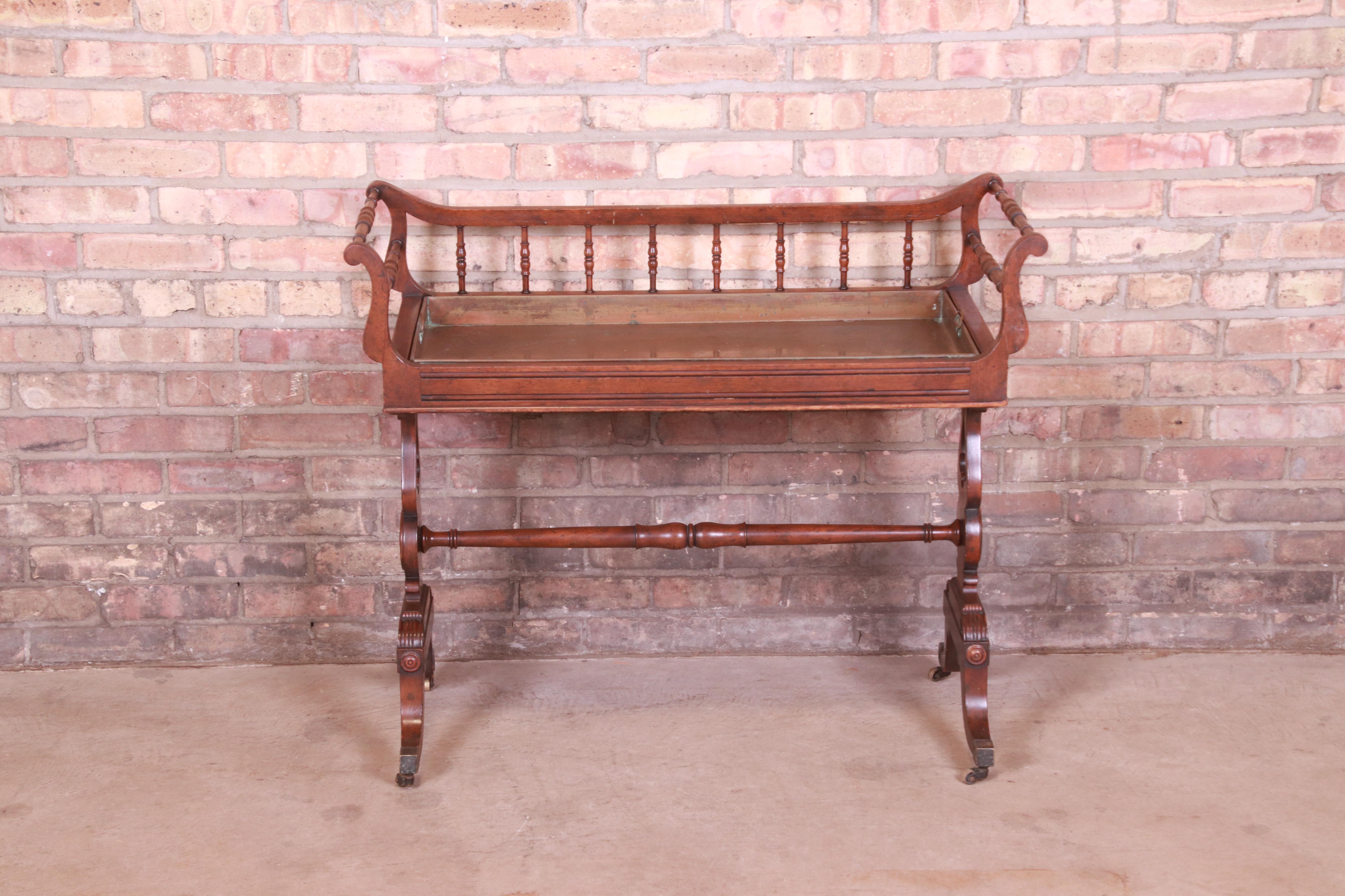 A gorgeous Georgian or Regency style tea cart 

By Baker Furniture 

USA, mid-20th century

Carved mahogany, with original copper pull-out tray. Could also be used as a planter.

Measures: 36.5