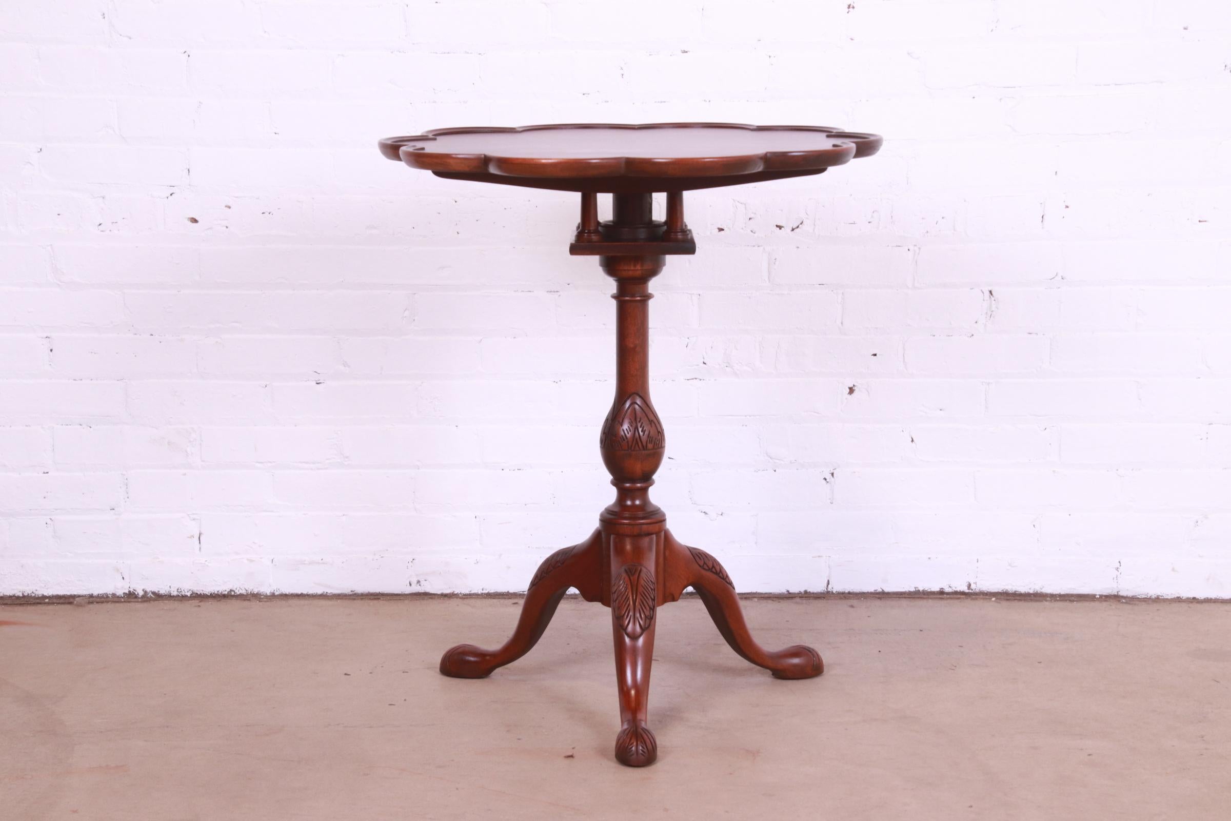 A gorgeous Georgian or Chippendale style carved mahogany tilt top pedestal tea table

By Baker Furniture

USA, Circa 1980s

Measures: 25