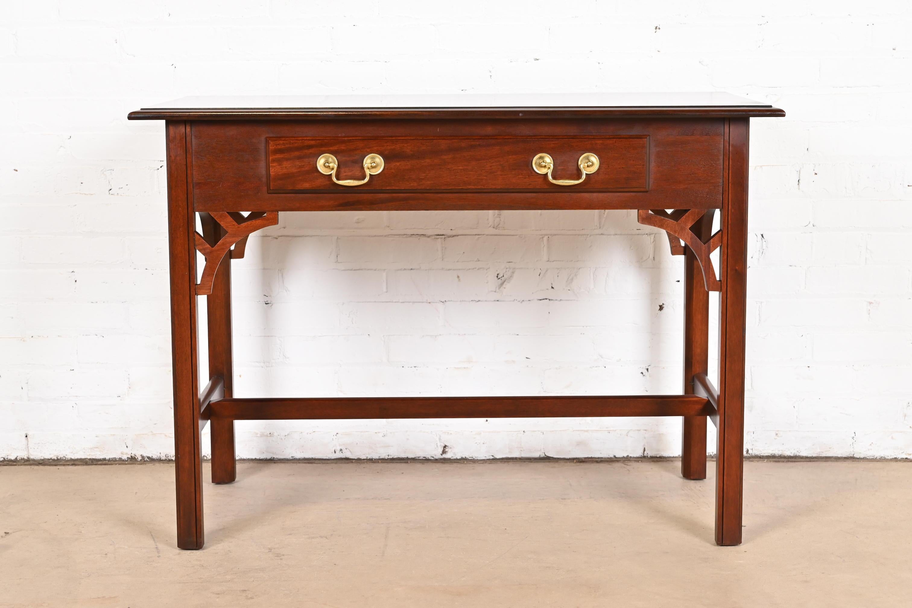 A gorgeous Georgian or Chippendale style writing desk, console table, or sofa table

By Baker Furniture

USA, Late 20th Century

Carved mahogany, with original brass hardware.

Measures: 42