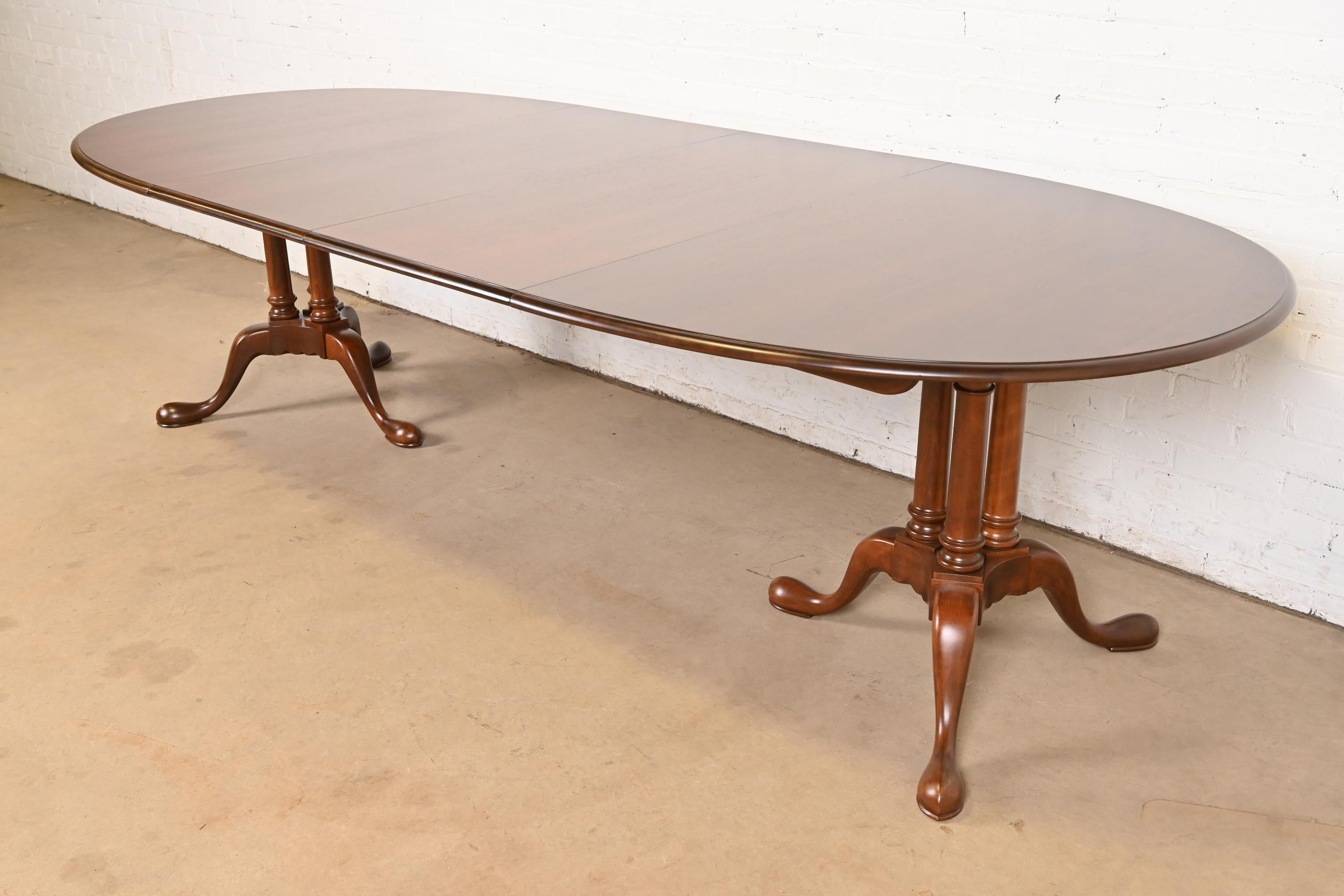 Exceptionnelle table de salle à manger à double piédestal de style Georgien, Regency ou Queen Anne.

Par Baker Furniture

USA, Circa 1980

Magnifique plateau en cerisier assorti aux livres, avec des piédestaux en cerisier massif sculpté.

Dimensions