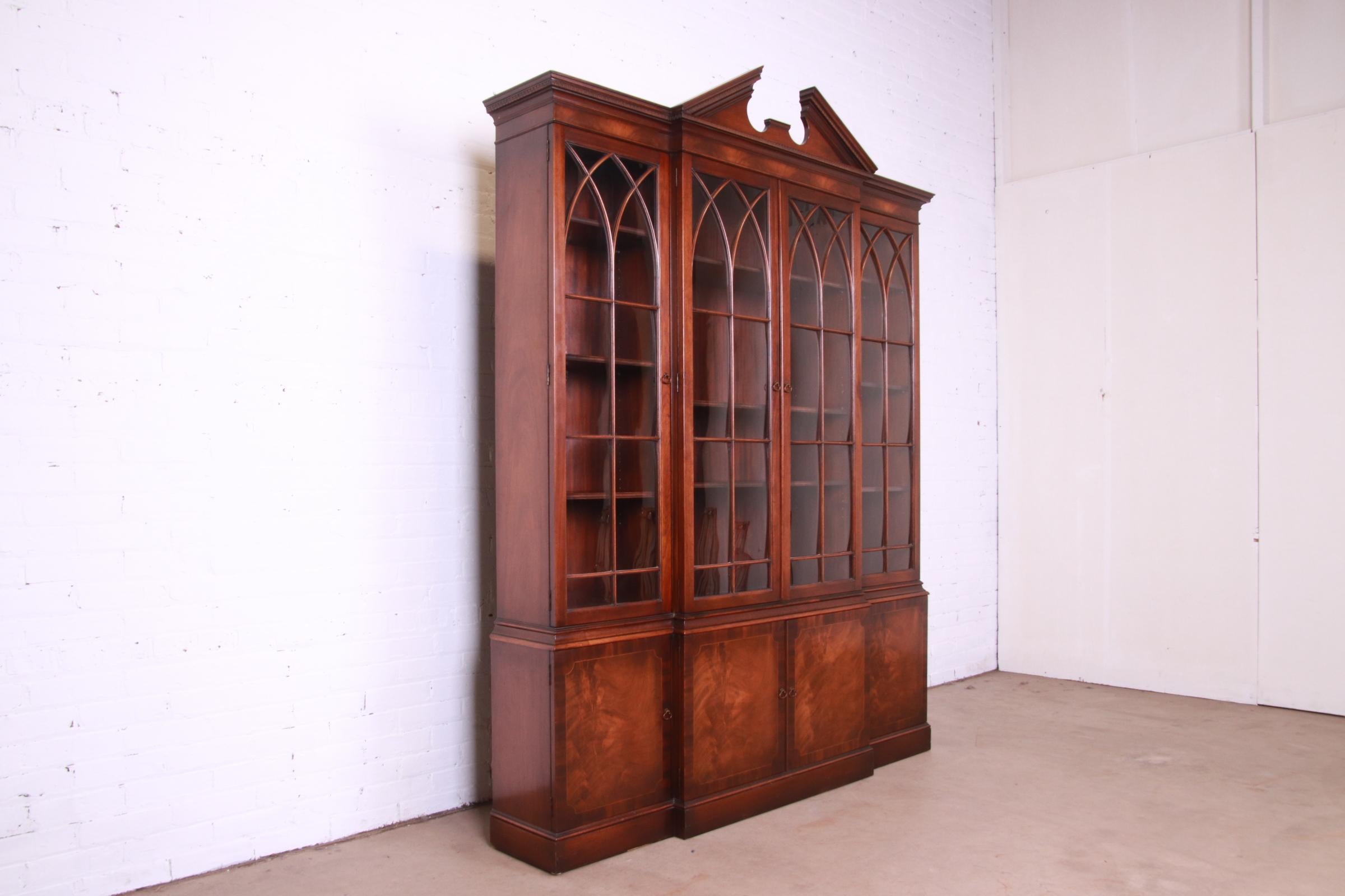 A gorgeous Georgian or Chippendale style breakfront bookcase cabinet or dining cabinet

By Baker Furniture

USA, Circa 1940s

Flame mahogany, with mullioned glass front doors and original brass hardware.

Measures: 67