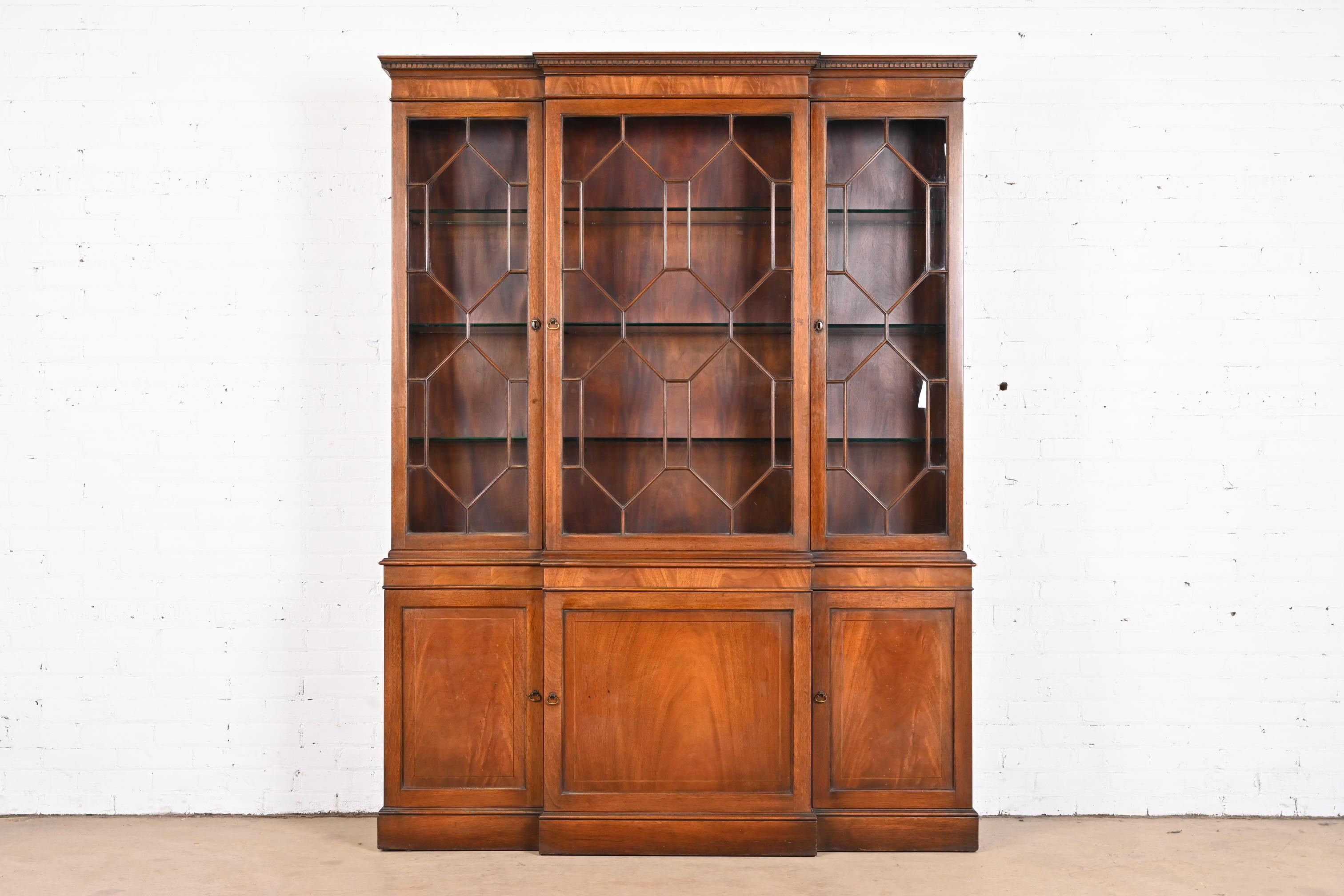 A gorgeous Georgian style lighted breakfront bookcase cabinet

By Baker Furniture

USA, 1940s

Flame mahogany, with mullioned glass front doors, and original brass hardware.

Measures: 61.75