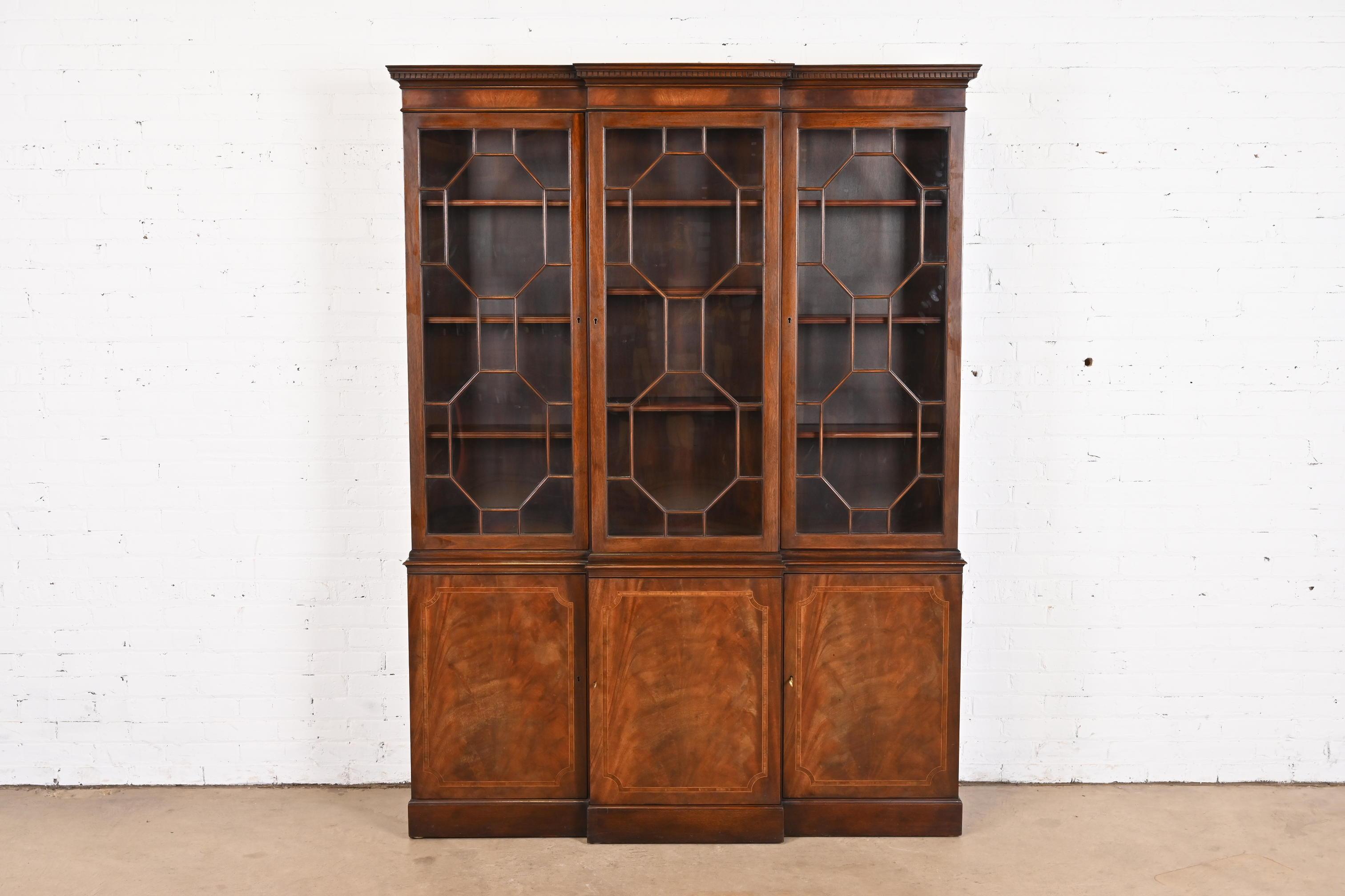 A gorgeous Georgian or Chippendale style breakfront bookcase or dining cabinet

By Baker Furniture

USA, Circa 1960s

Book-matched flame mahogany, with satinwood inlay, mullioned glass front doors, and original brass hardware. Cabinets lock, and