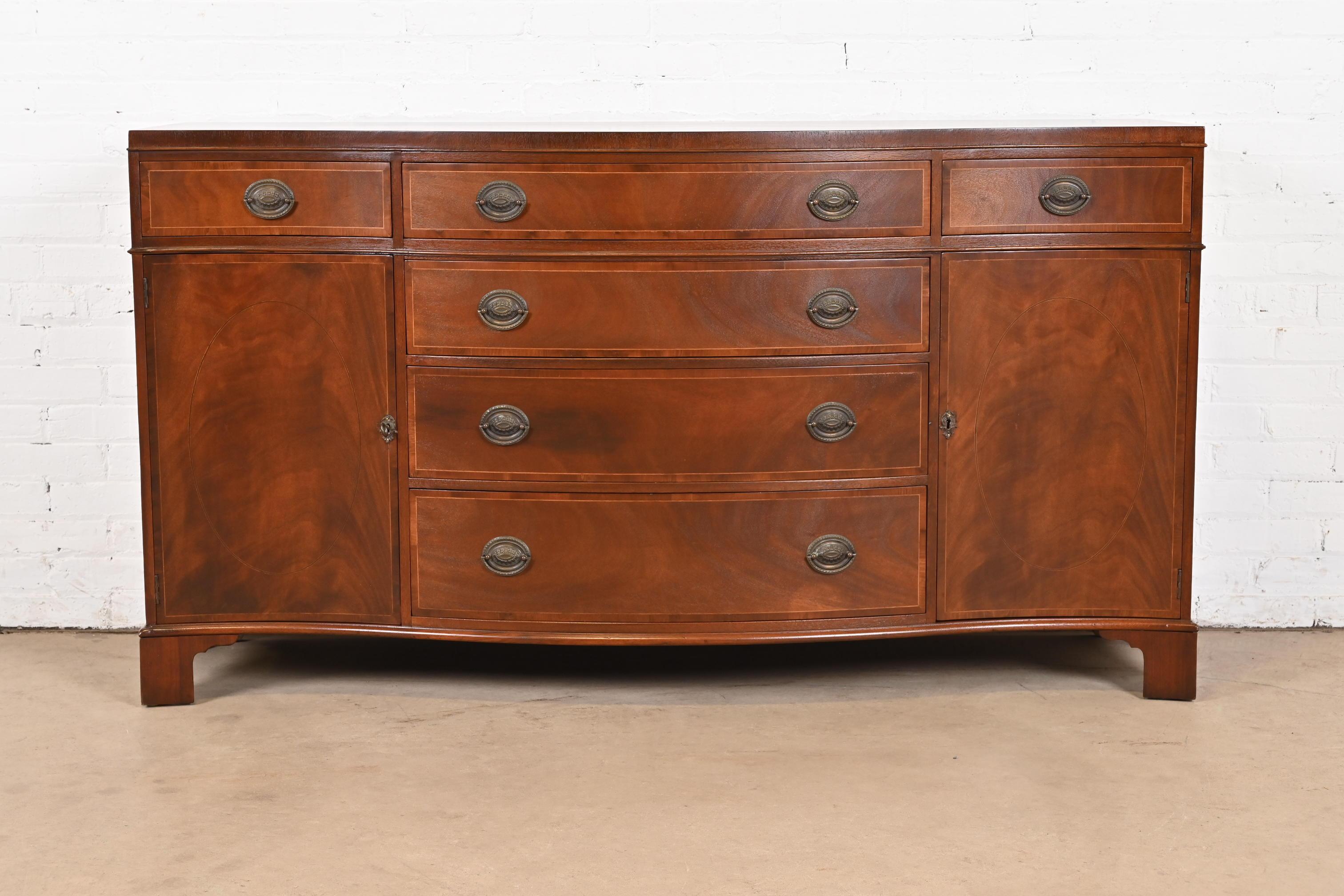 Una splendida credenza, credenziere o mobile bar in stile georgiano o reggenza

Da Baker Furniture

USA, circa anni '40

Bellissimo mogano a fiamma, con intarsio di corde in legno satinato e hardware originale in ottone.

Misure: 64,25