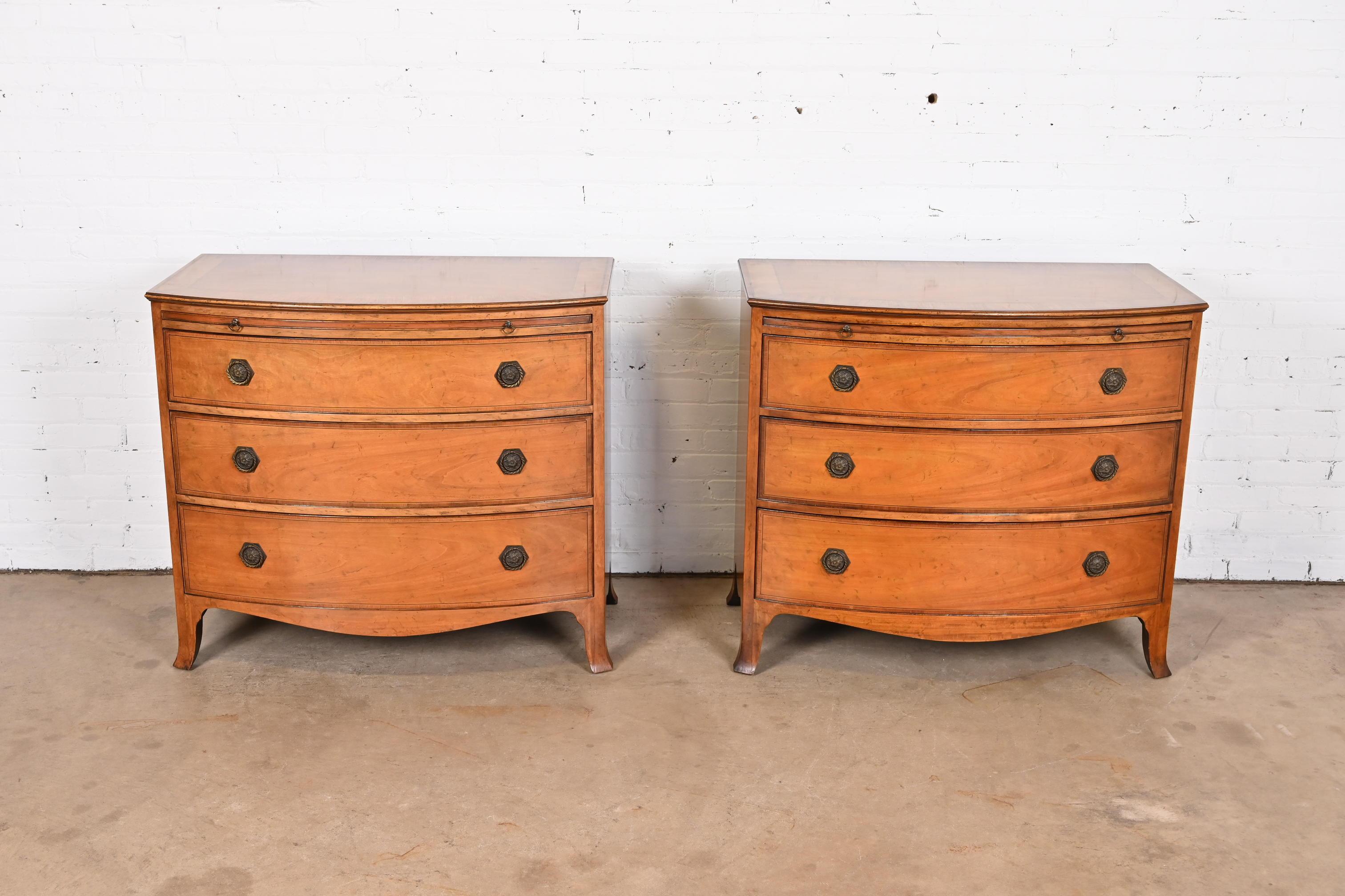 A gorgeous pair of Georgian bow front commodes, dressers, or chests of drawers

By Baker Furniture

USA, Circa 1950s

Mahogany, with satinwood and ebony string inlay, embossed leather pull-out trays, and original brass hardware.

Measures: