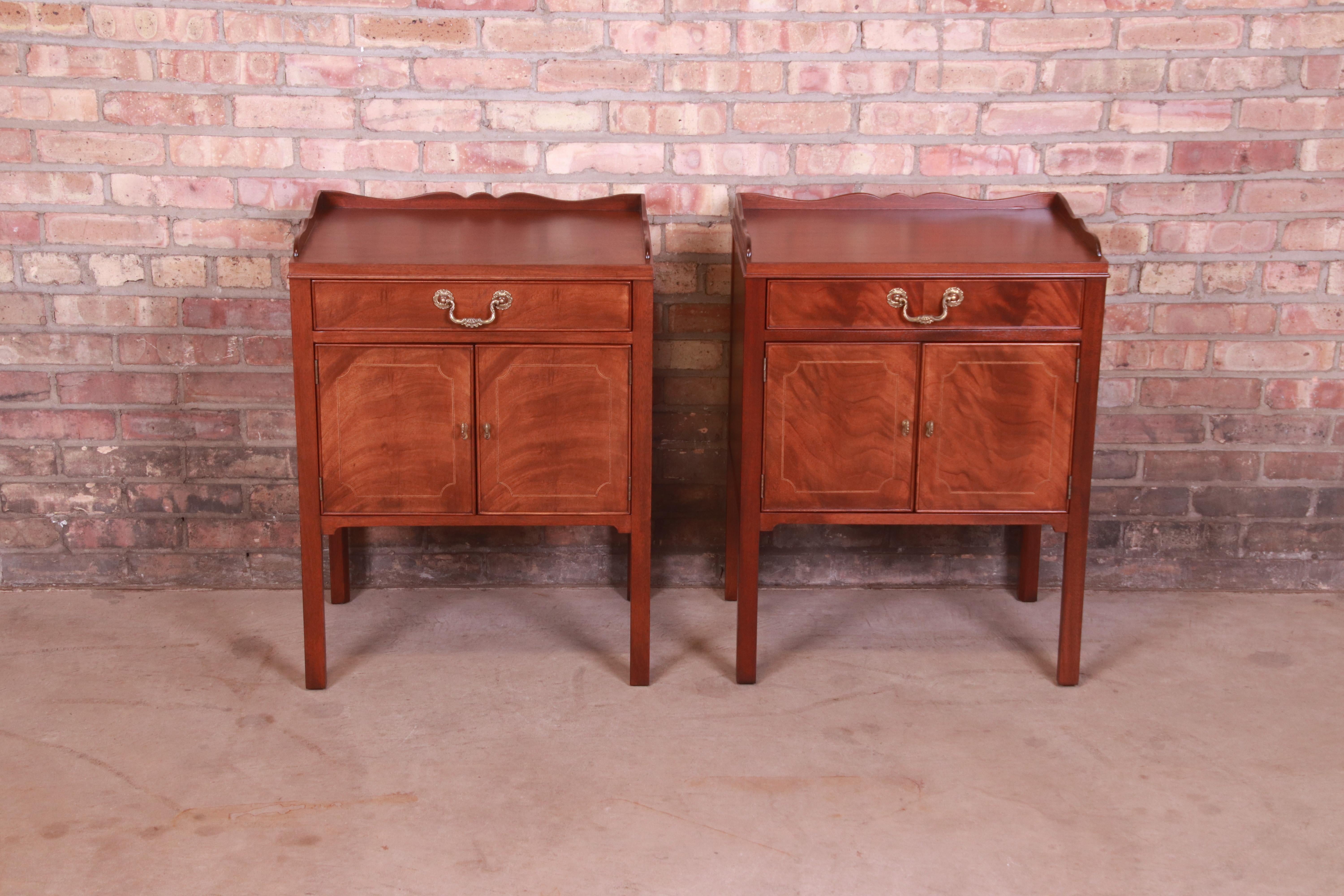 A gorgeous pair of Georgian or Chippendale style bedside tables

By Baker Furniture

USA, Circa 1980s

Flame mahogany, with satinwood inlay and original brass hardware.

Measures: 22.25