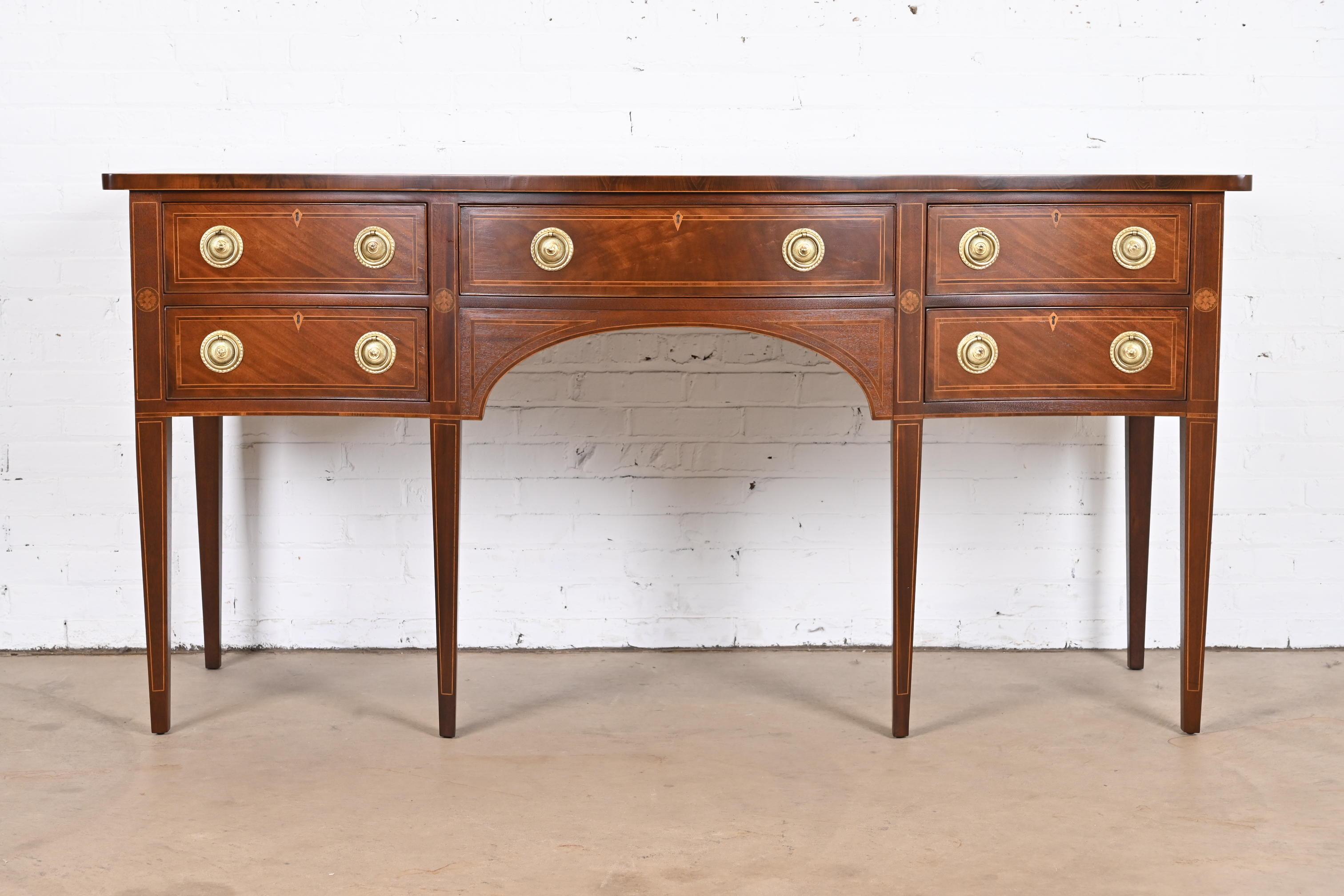 A gorgeous Georgian or Hepplewhite style serpentine front sideboard buffet or credenza

By Baker Furniture

USA, Circa 1980s

Mahogany, with satinwood inlay and original brass hardware.

Measures: 72