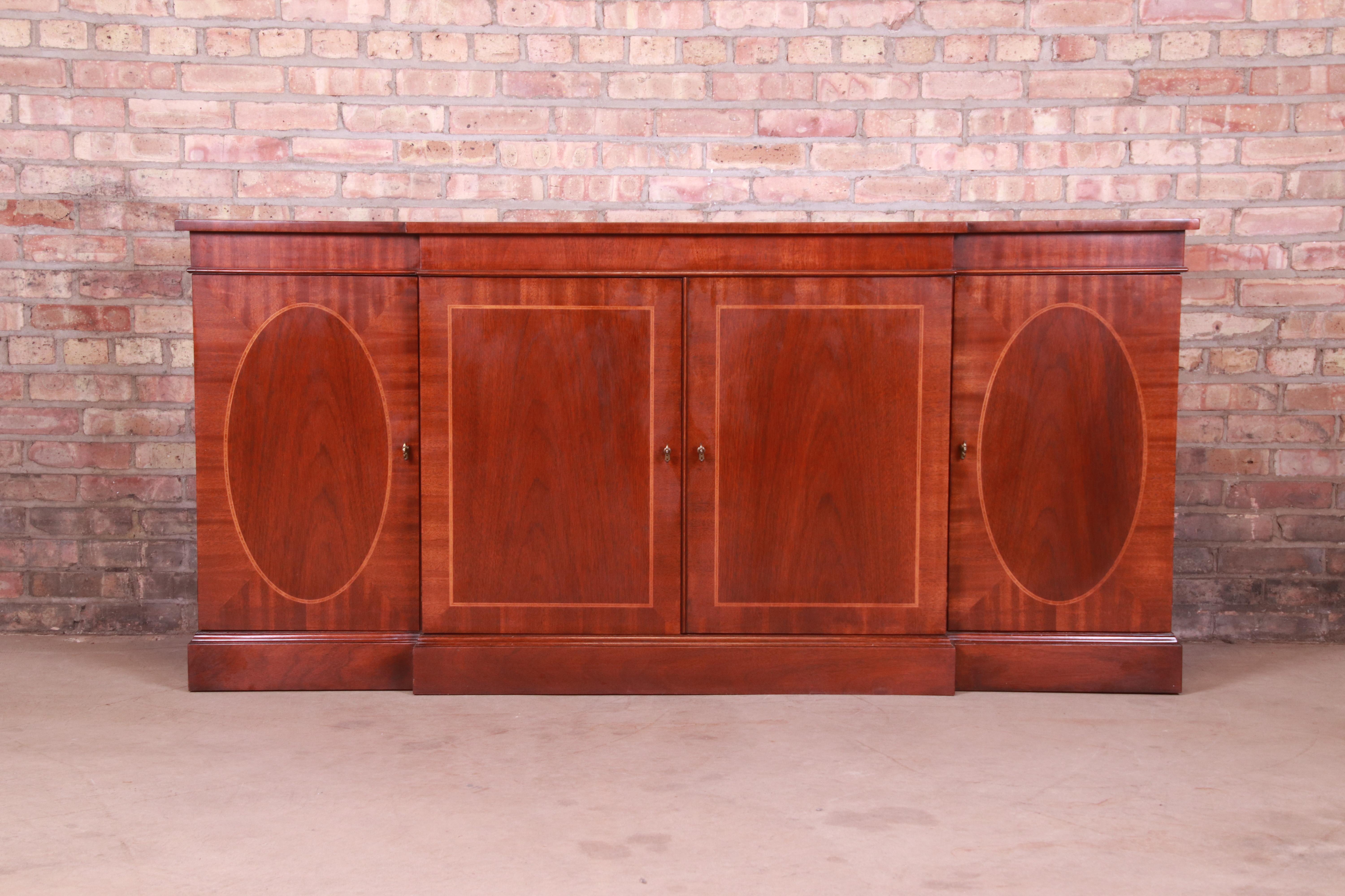 A gorgeous Georgian style sideboard, credenza, or bar cabinet

By Baker Furniture

USA, Circa 1980s

Book-matched mahogany, with satinwood inlay and original brass hardware.

Measures: 72