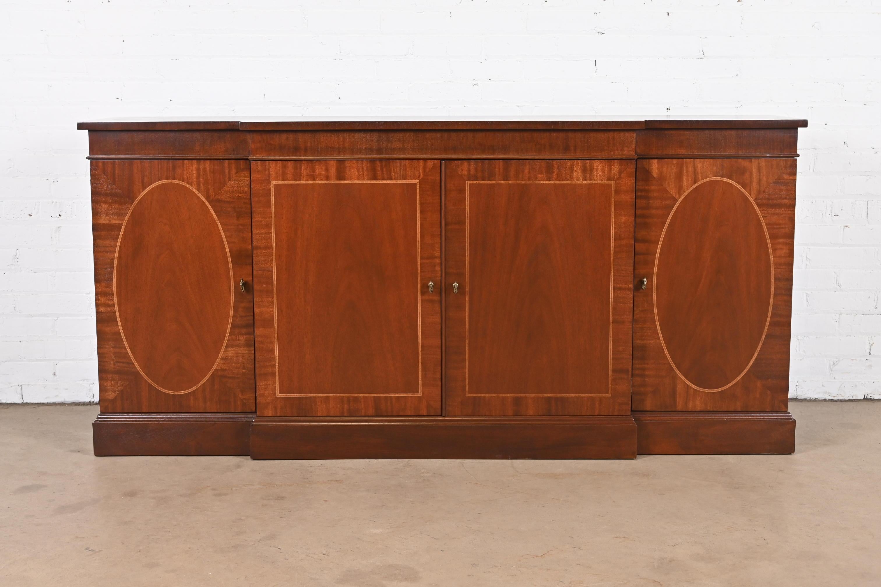 A gorgeous Georgian style sideboard, credenza, or bar cabinet

By Baker Furniture

USA, Circa 1980s

Book-matched mahogany, with satinwood inlay and original brass hardware.

Measures: 72