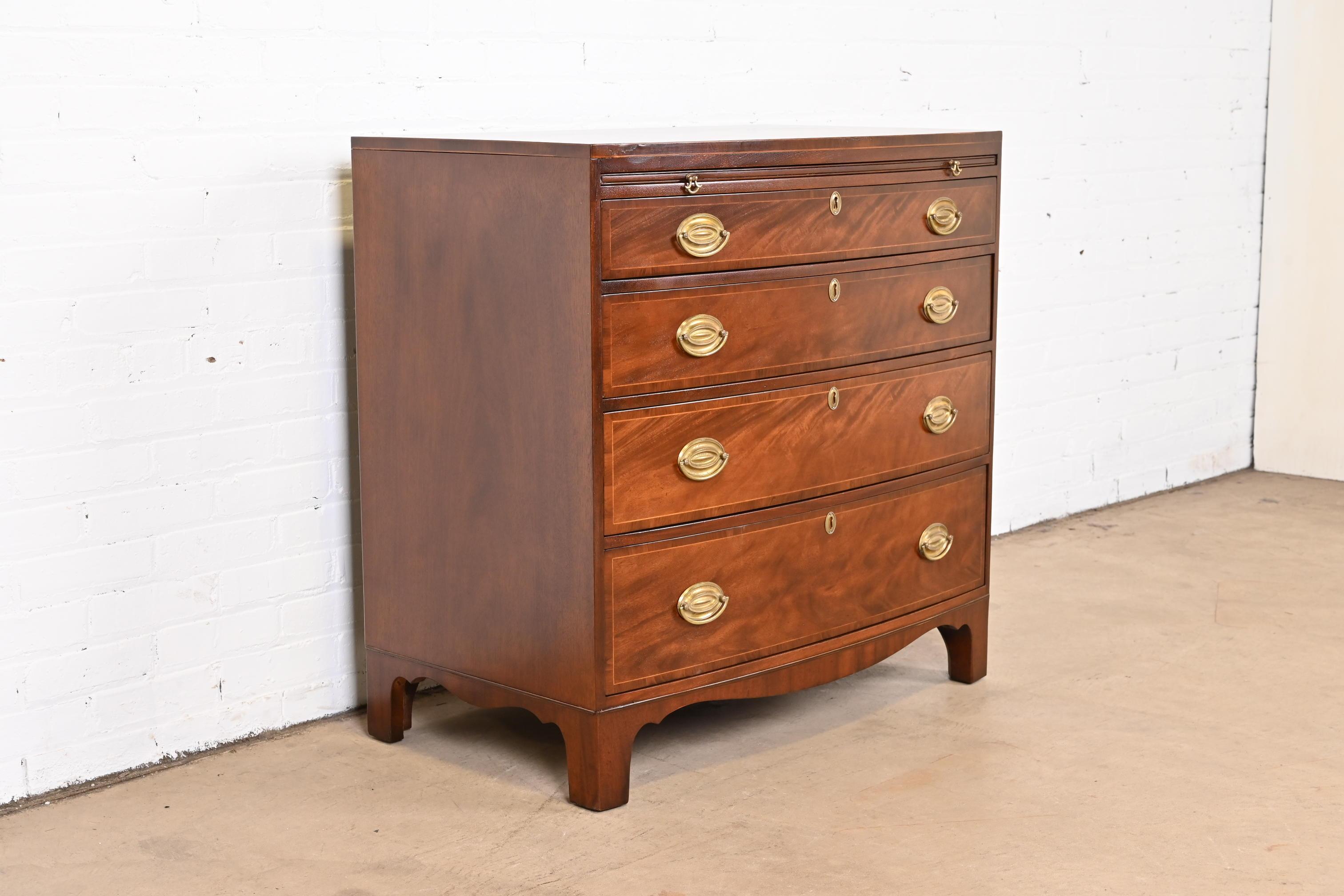 A gorgeous Georgian bow front dresser or bachelor chest of drawers

By Baker Furniture

USA, Circa 1940s

Flame mahogany, with satinwood string inlay, and original brass hardware.

Measures: 35