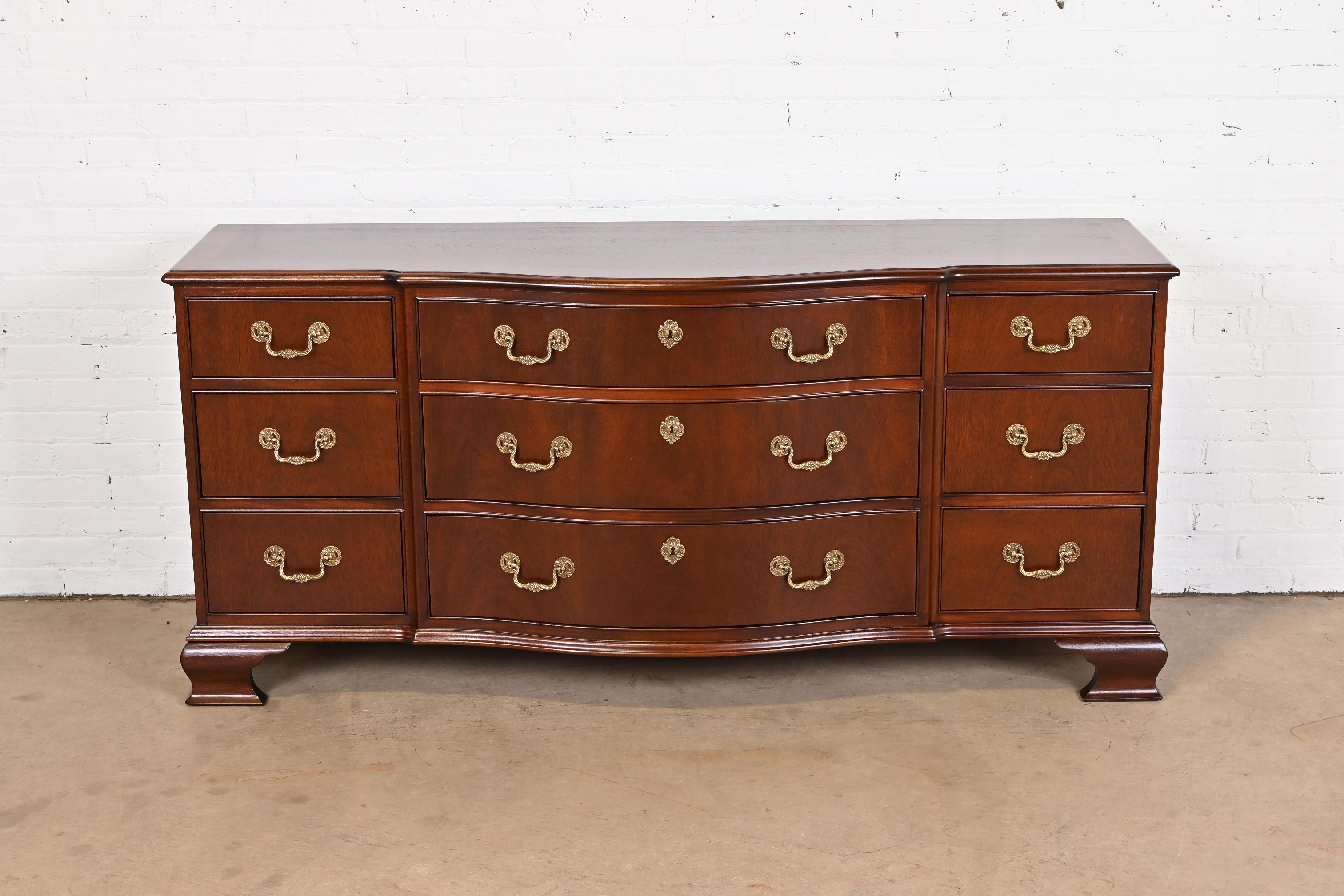 An exceptional Georgian or Chippendale style bow front triple dresser or credenza

By Baker Furniture

USA, Circa 1980s

Carved mahogany, with satinwood and ebony string inlay and original brass hardware.

Measures: 70