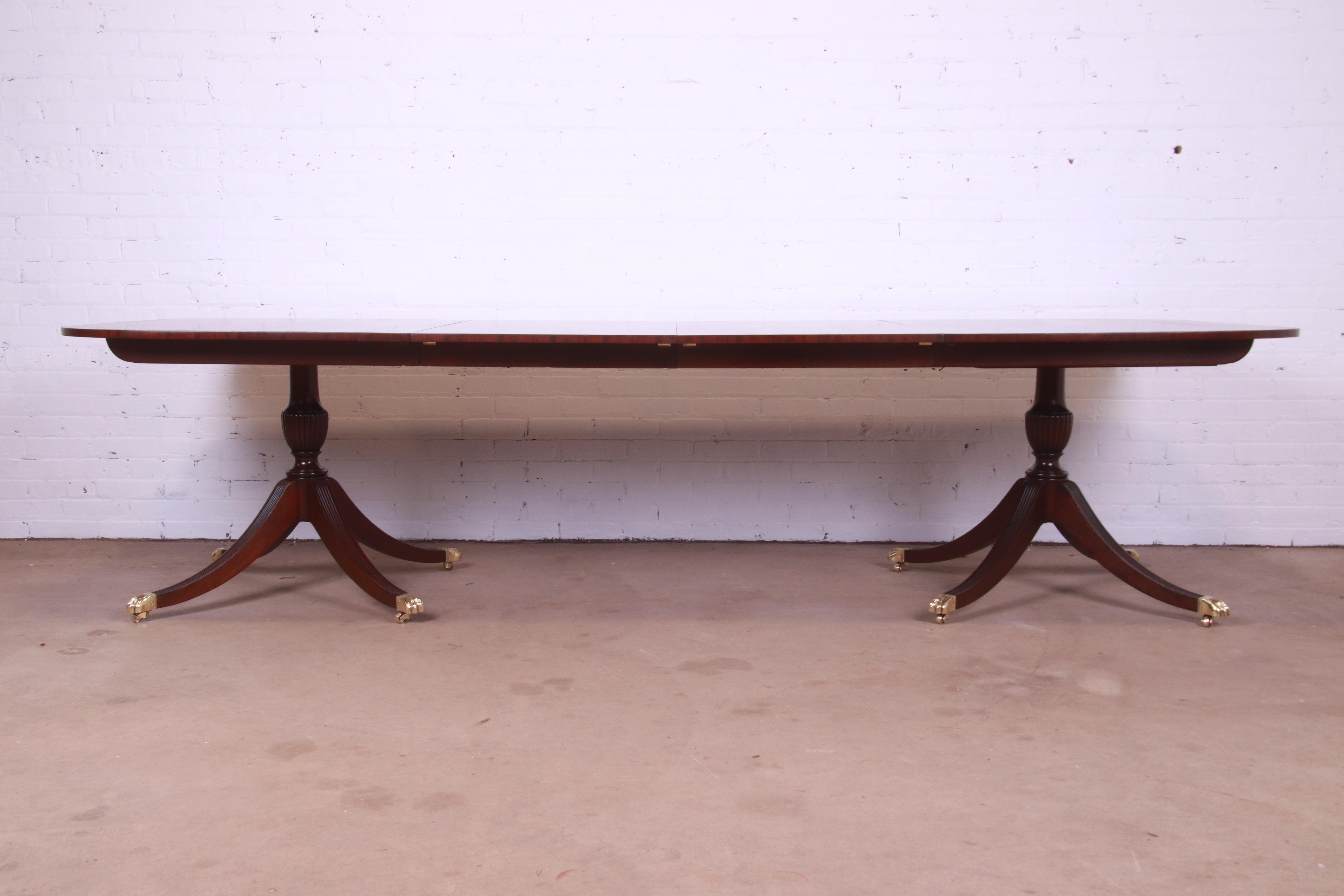 A gorgeous Georgian style double pedestal extension dining table

By Baker Furniture

USA, Circa 1940s

Banded mahogany, with satinwood inlay, carved solid mahogany pedestals, brass-capped paw feet, and brass casters.

Measures: 67.75