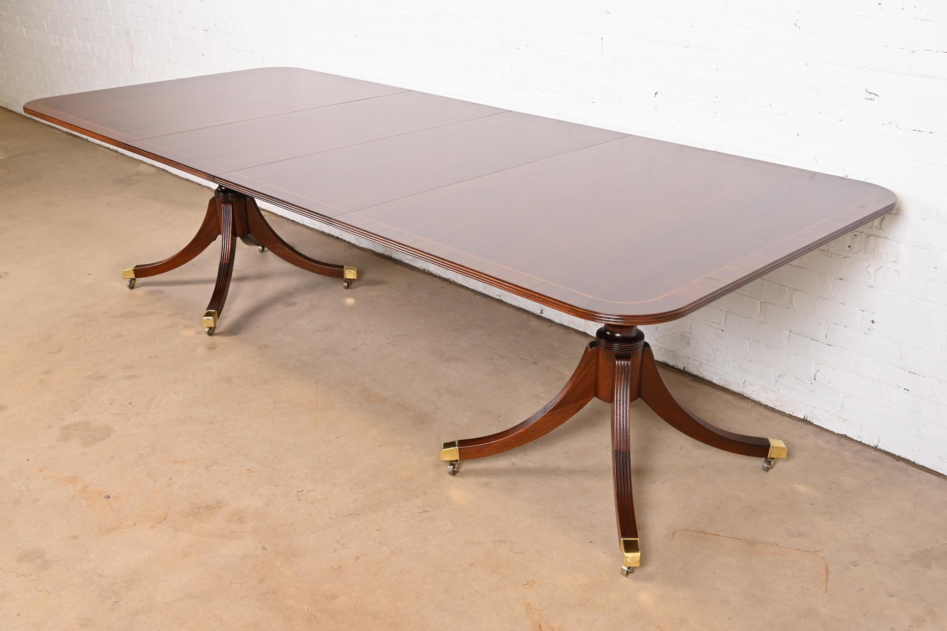 Ein prächtiger Esstisch im georgianischen oder Regency-Stil mit doppeltem Sockel und Verlängerung

Von Baker Furniture, 