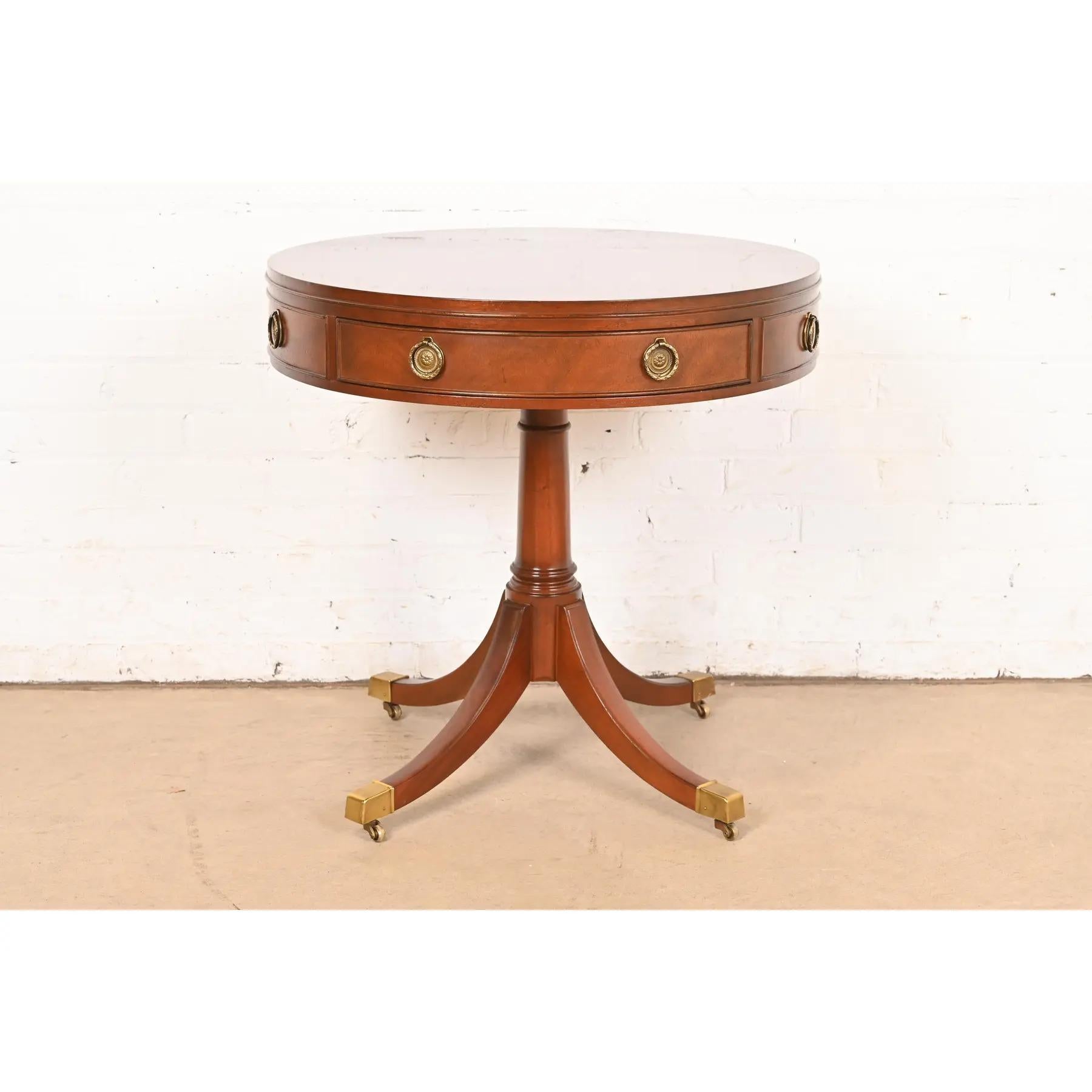 A gorgeous Georgian or Regency style pedestal drum side table or tea table

By Baker Furniture

USA, Circa 1980s

Mahogany, with original brass hardware, and brass-capped feet on brass casters.

Measures: 26