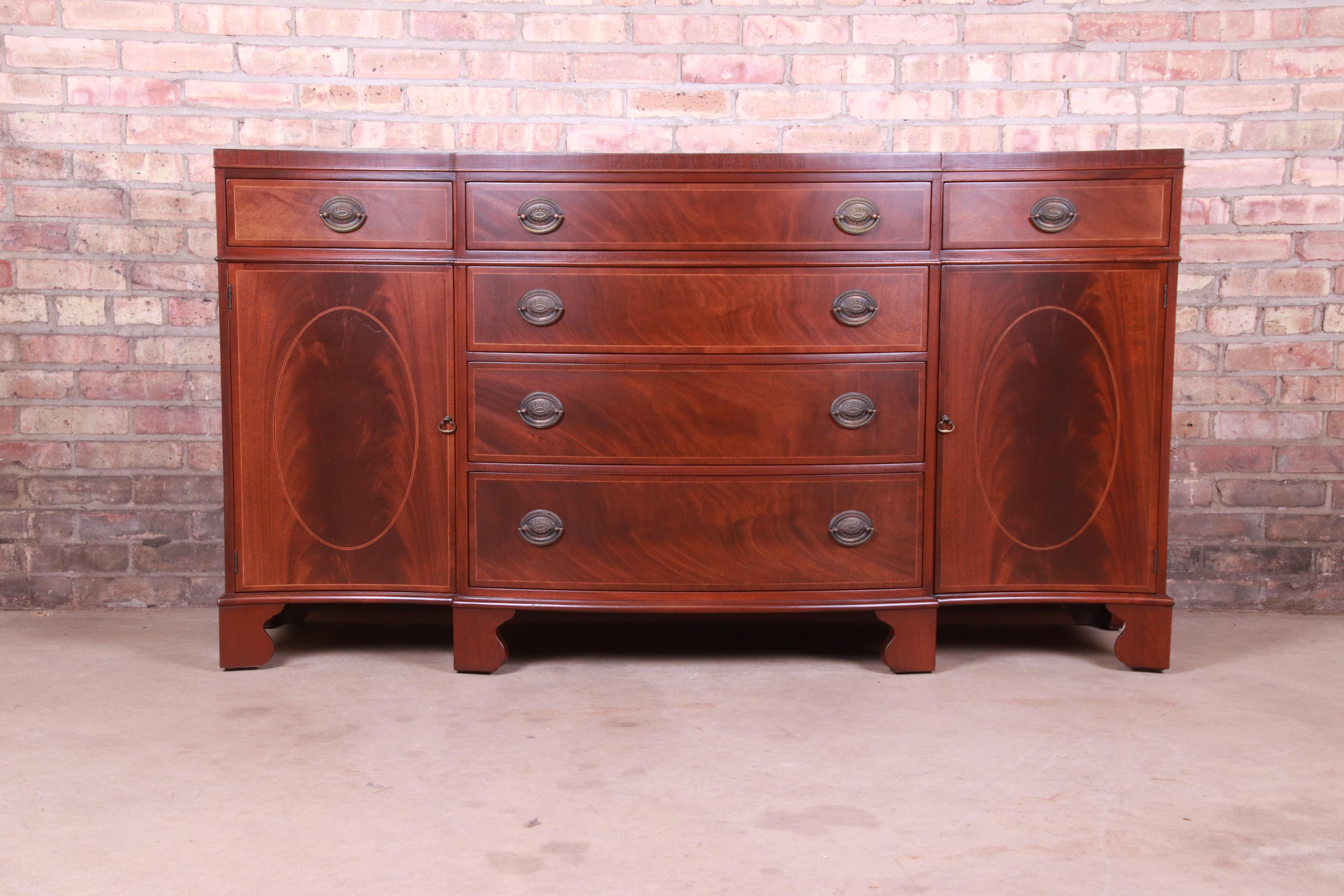 A gorgeous Georgian style sideboard, credenza, or bar cabinet

By Baker Furniture

USA, Circa 1950s

Book-matched mahogany, with satinwood string inlay and original brass hardware.

Measures: 65