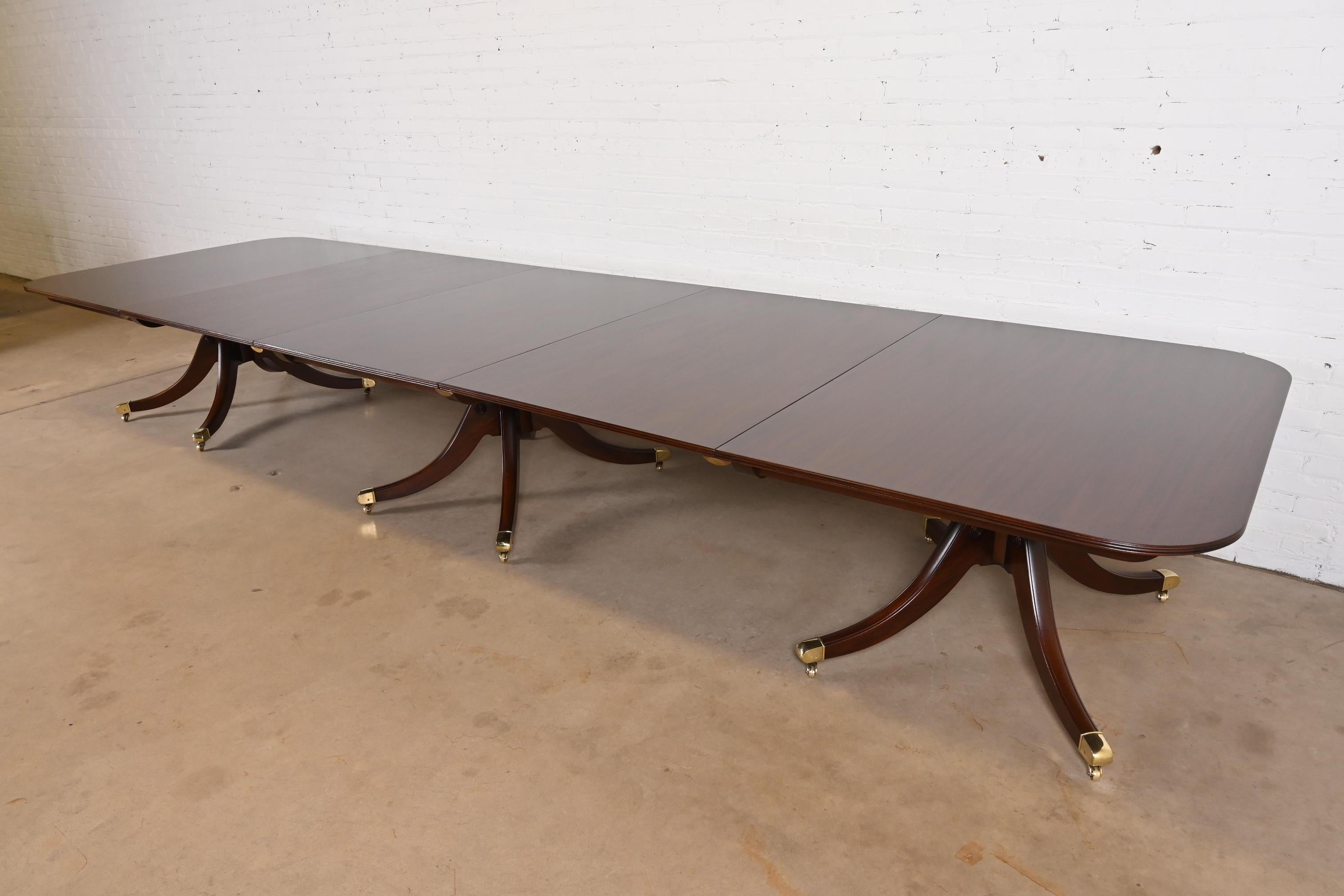 Magnifique table de salle à manger ou table de banquet monumentale à triple piédestal de style géorgien ou régence.

Par Baker Furniture

USA, Circa 1960

Magnifique acajou, avec des piédestaux en acajou massif sculpté, et des pieds coiffés de