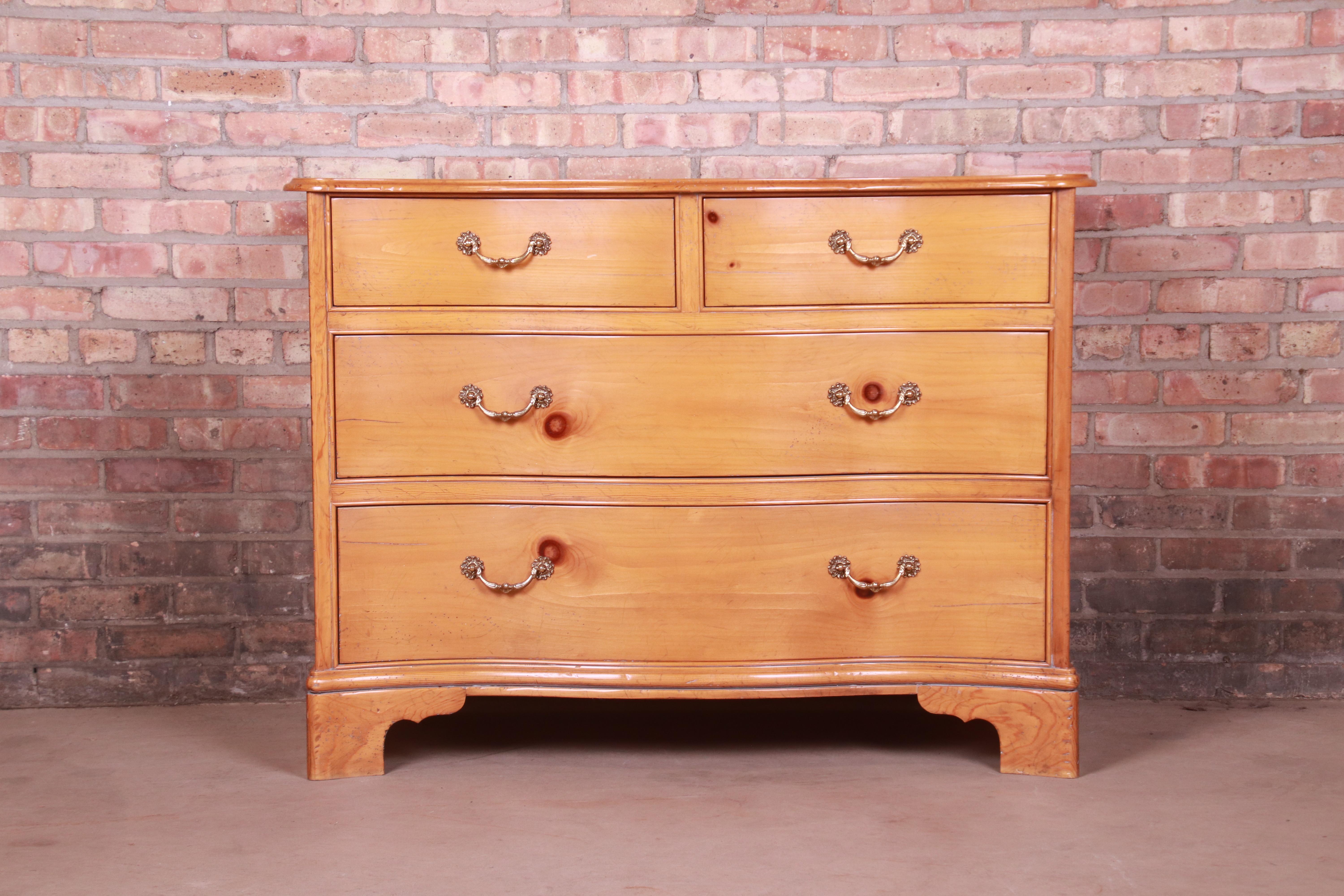 A gorgeous Georgian style serpentine dresser or chest of drawers

By Baker Furniture

USA, Late 20th Century

Knotty pine, with original brass hardware.

Measures: 45