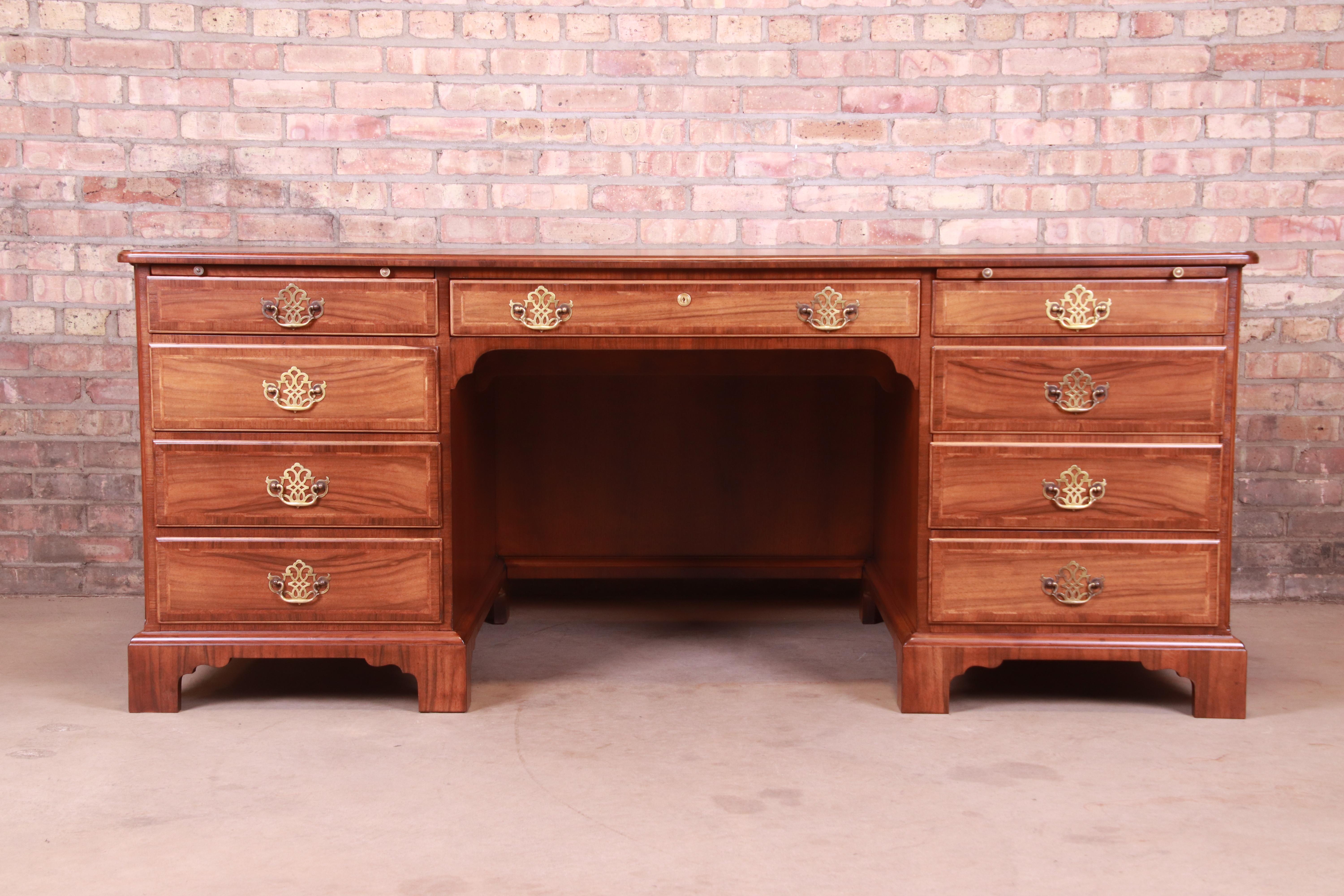 A stately Georgian or Chippendale style executive desk with inlaid leather top

By Baker Furniture

USA, 1950s

Gorgeous figured walnut, with original brass pulls and inlaid embossed leather top.

Measures: 72