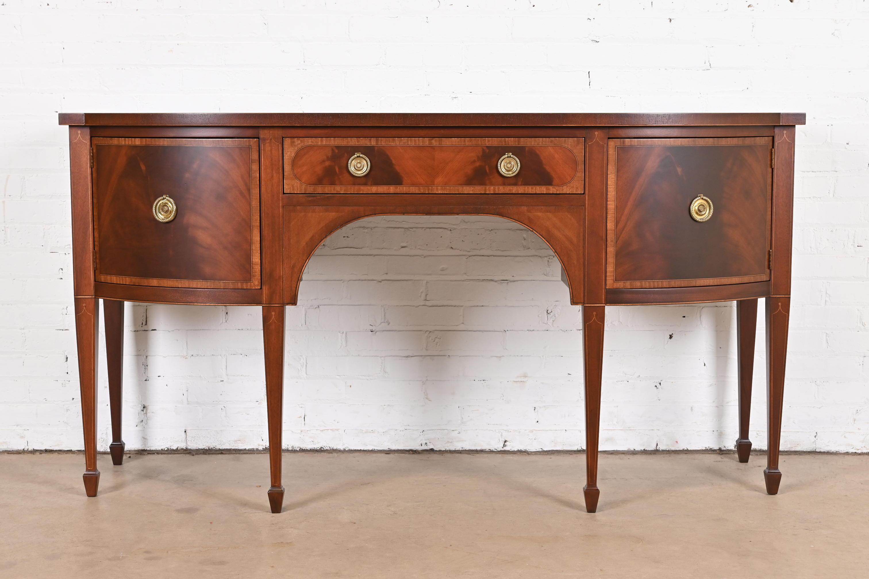 An exceptional Hepplewhite or Federal style bow front sideboard, buffet, or credenza

By Baker Furniture

USA, Circa 1980s

Gorgeous flame mahogany, with satinwood banding and string inlay, and original brass hardware.

Measures: 68